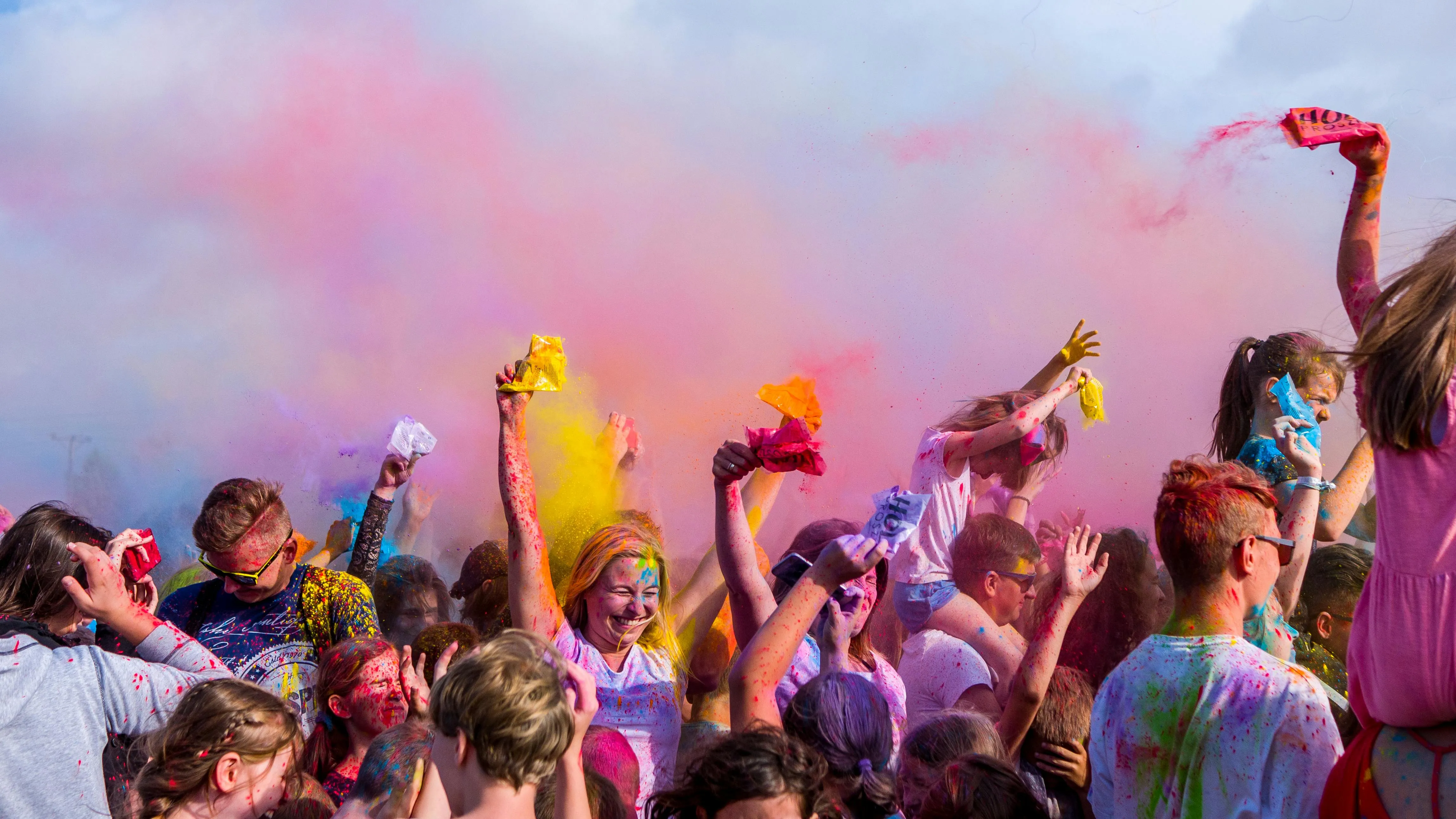 crowd of people spilling colors on each other during holi festival