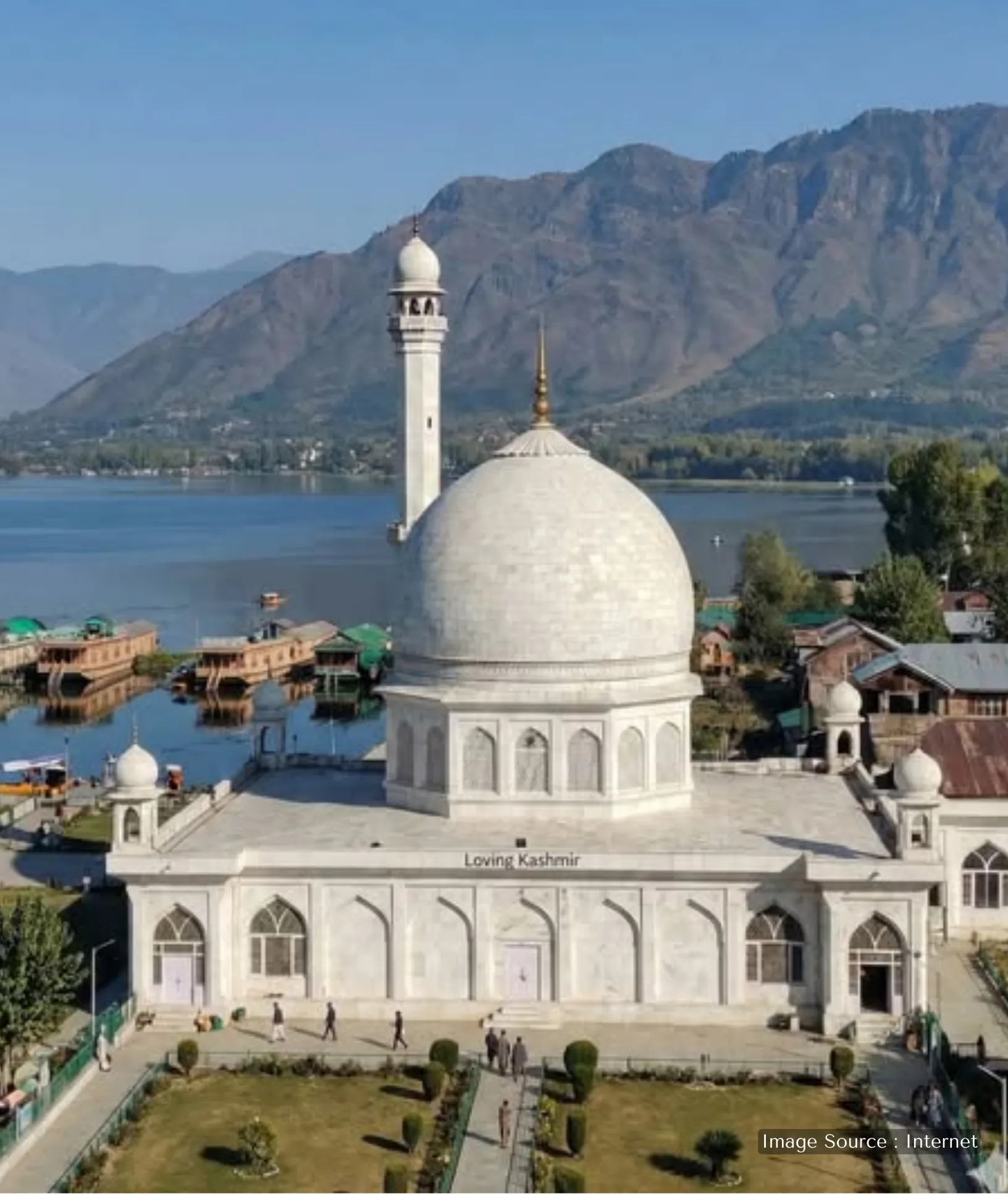 The white marble Hazratbal Shrine in Srinagar, located on the banks of Dal Lake with houseboats and mountains in the background.