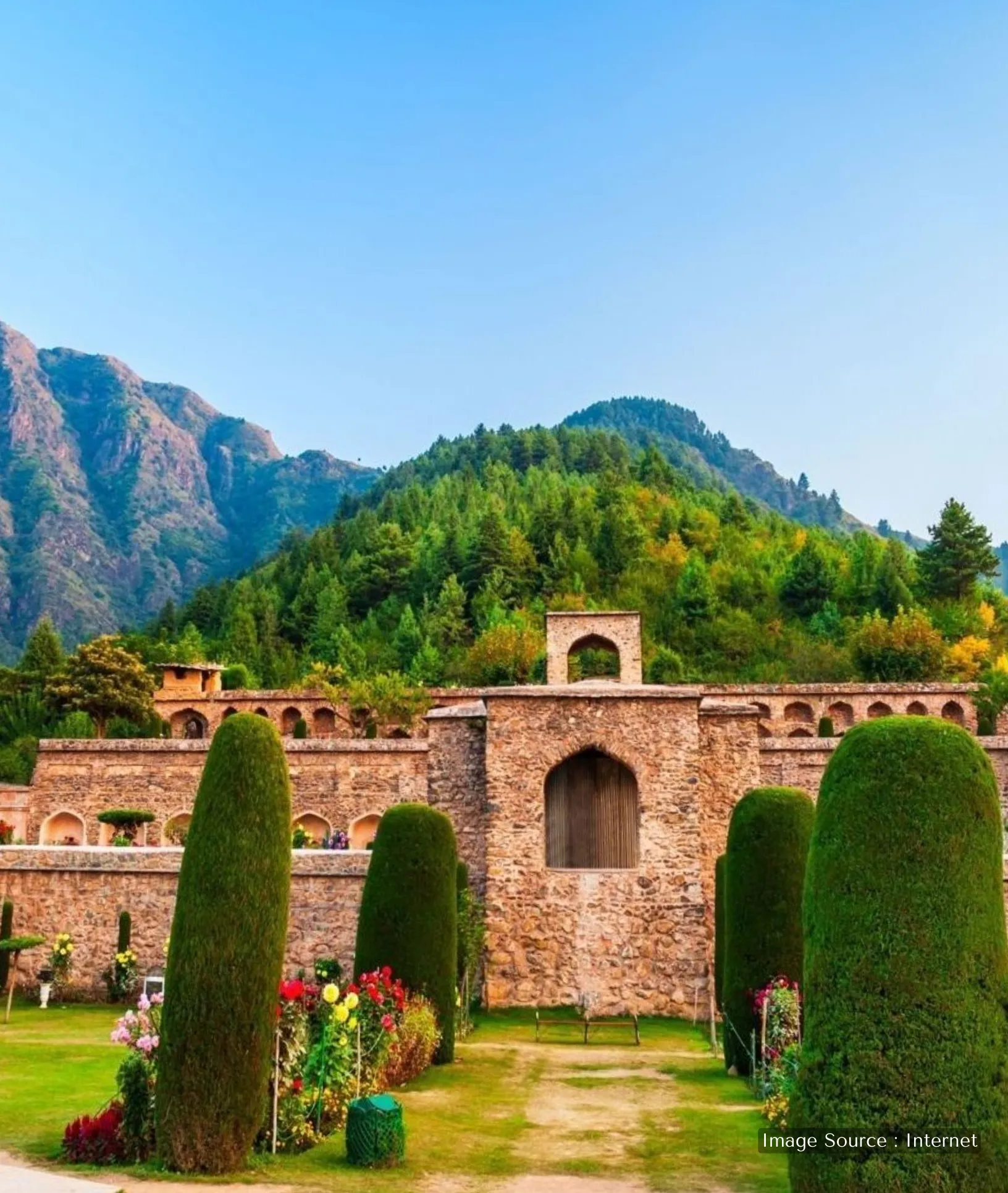 The seven-terraced Pari Mahal garden in Srinagar, featuring historic stone arches, tall cypress trees, and lush green hillsides.