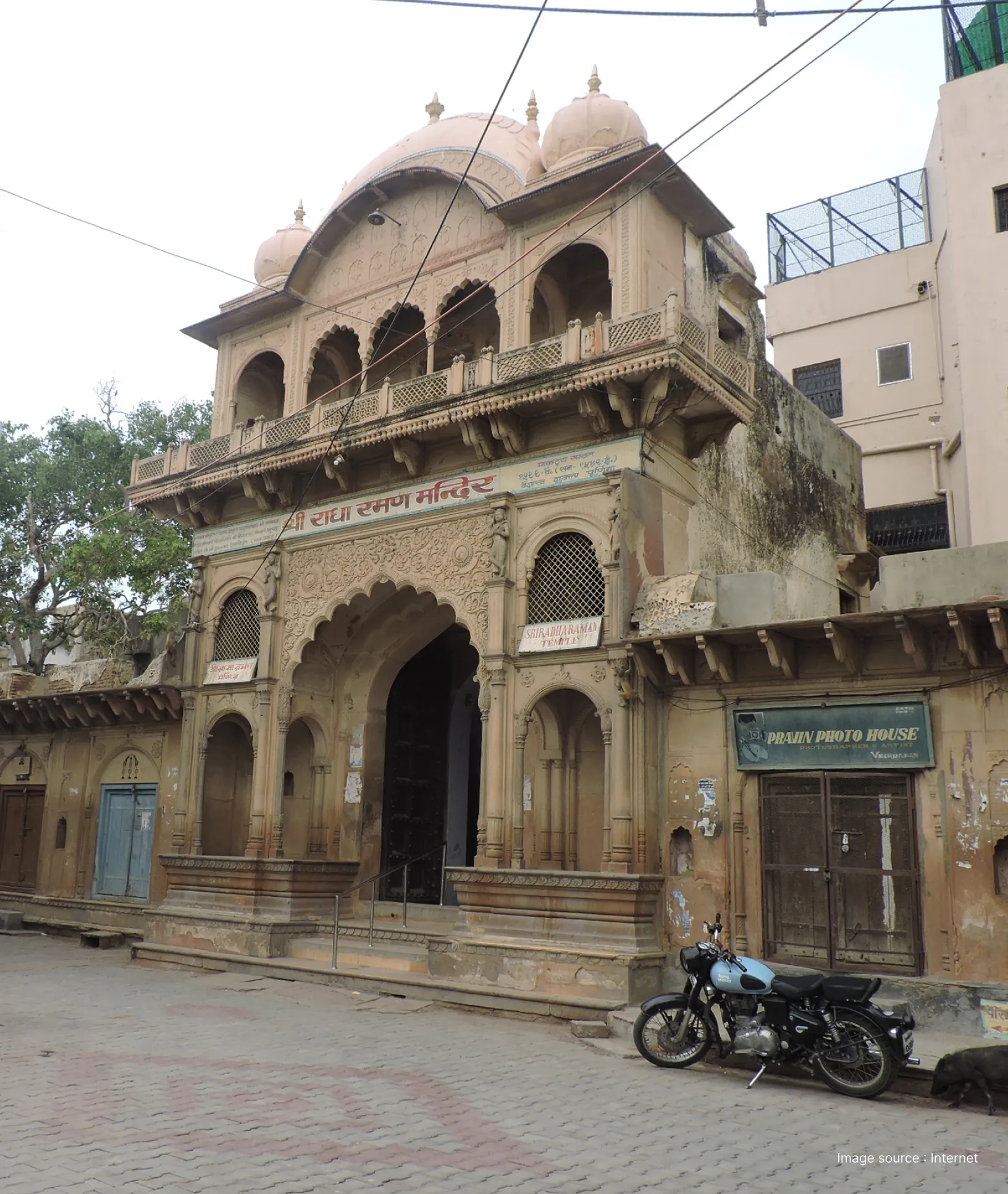 Historic facade and arched entrance of Shri Radha Raman Temple in Vrindavan, featuring traditional sandstone carvings.