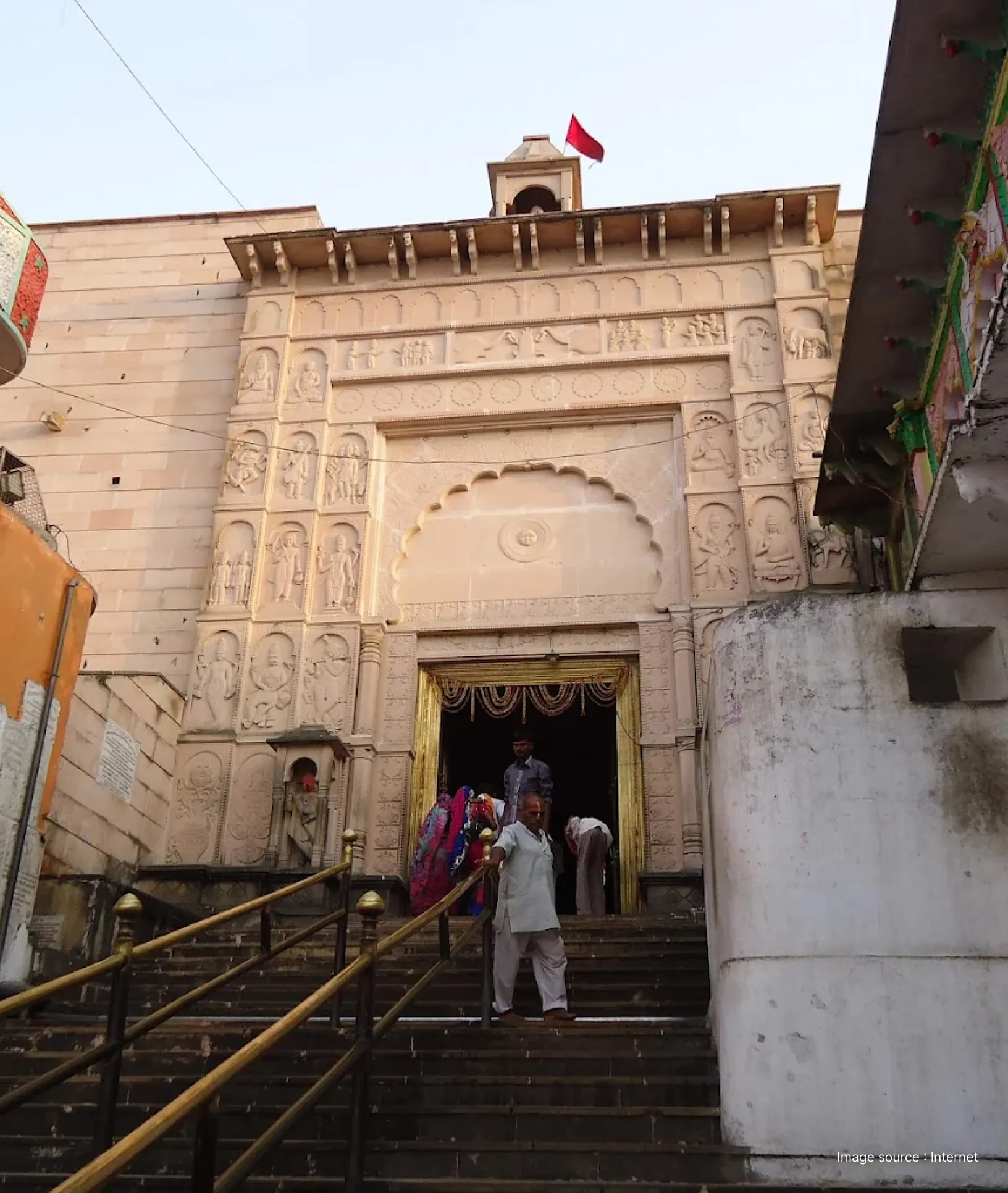 Shri Hanuman Garhi Mandir entrance in Ayodhya, featuring intricately carved stone gateway and devotees ascending the temple steps