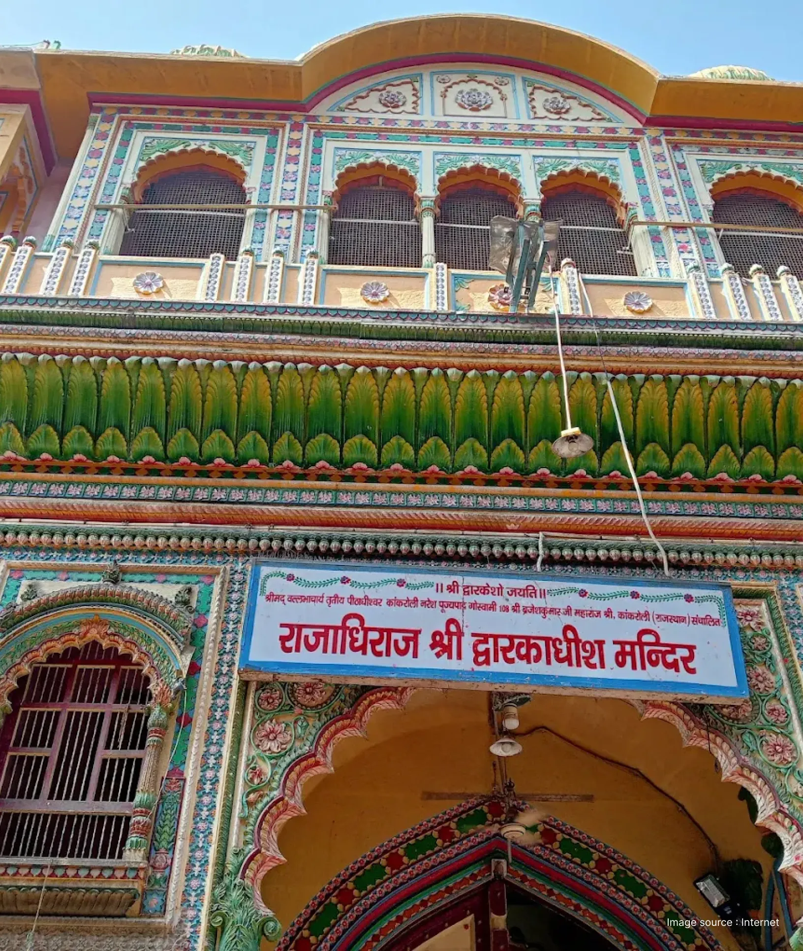 Detailed view of the brightly painted entrance and Rajasthani-style carvings of the Dwarkadhish Temple in Mathura.