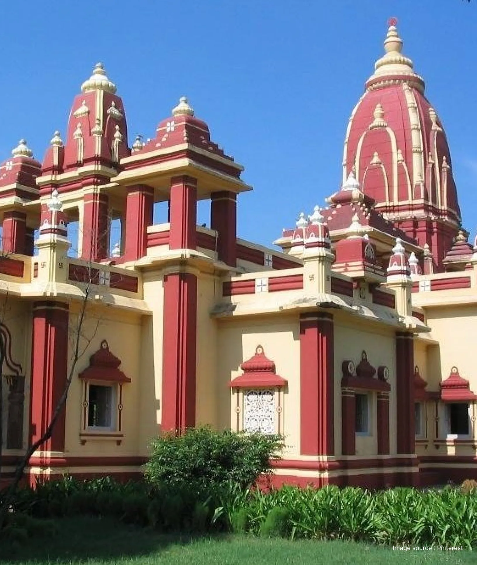 The red and white towers of the Birla Mandir (Gita Mandir) in Mathura set against a clear blue sky.