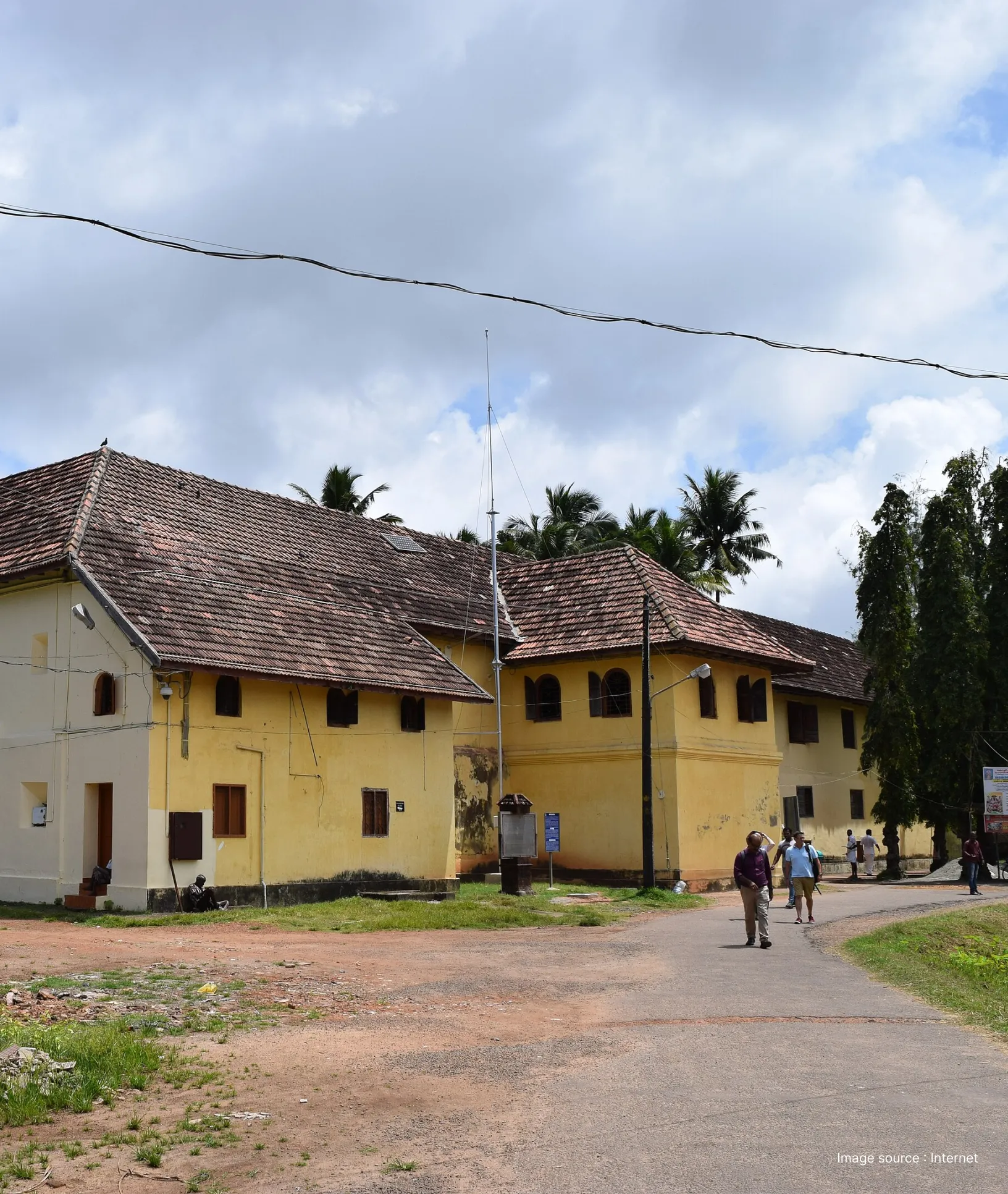 The Dutch Palace (Mattancherry Palace) in Kochi featuring traditional Kerala architecture with visitors walking on the grounds.