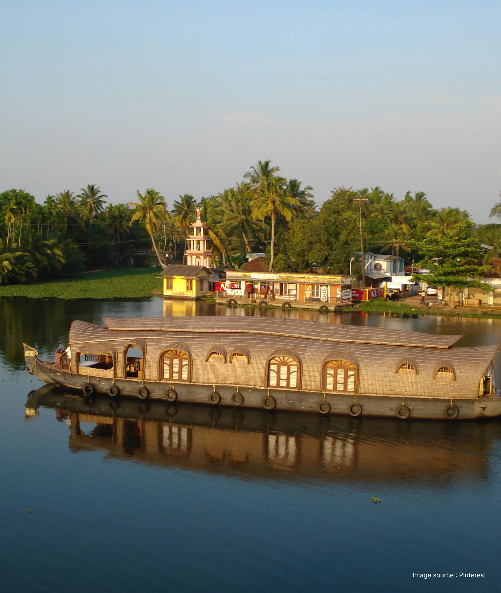 a traditional rice vessel boat floating on the backwaters of kuttanad