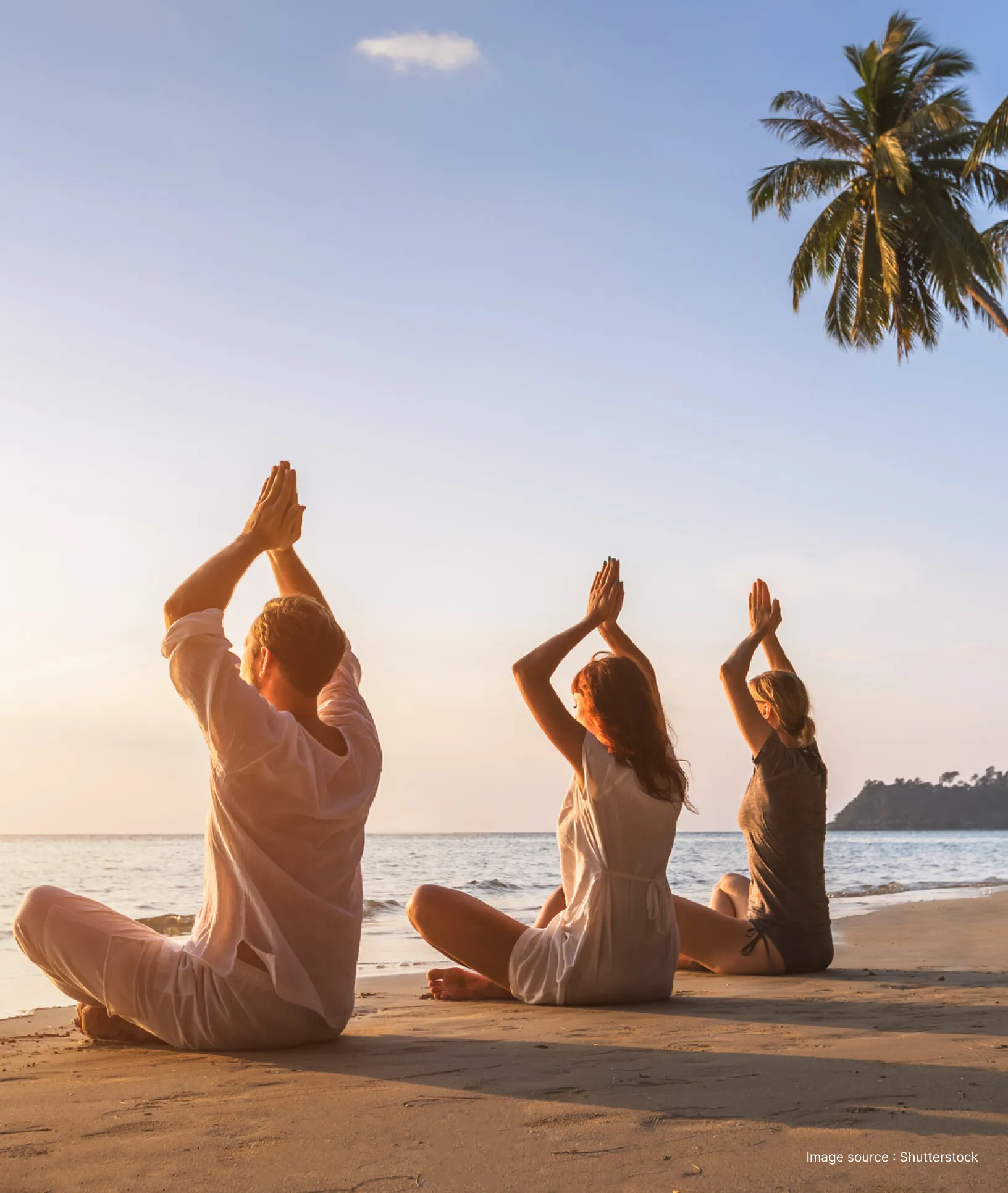 three people practicing yoga asanas at a sea beach