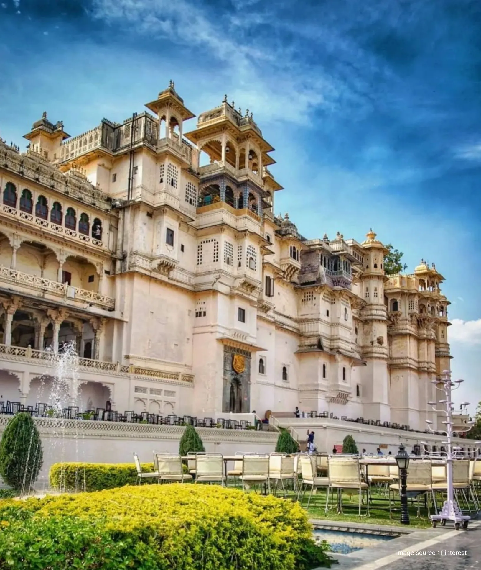 side angled view of the ancient city palace complex in udaipur with gardens in the front