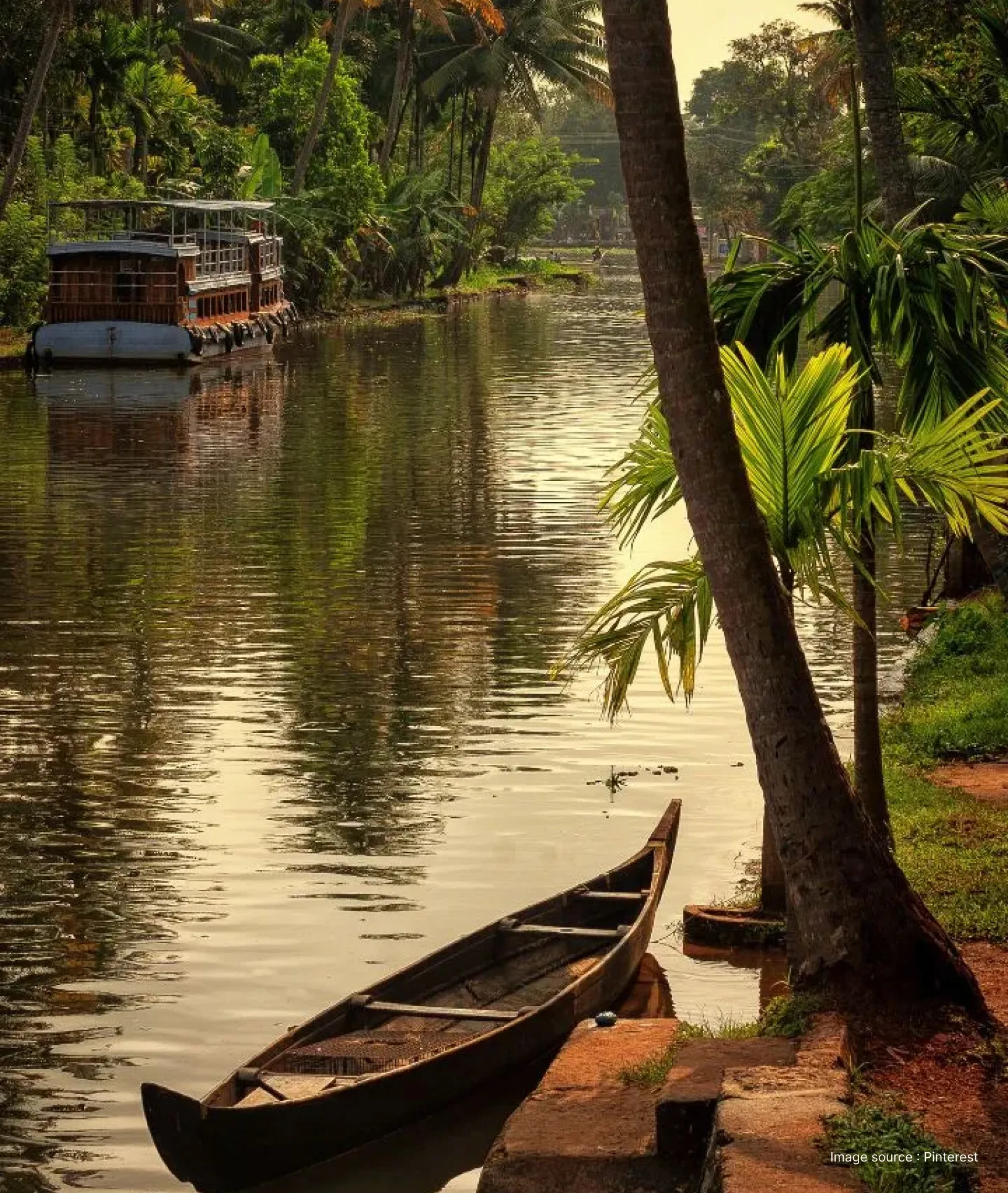 a wooden boat sitting at the shore of a backwater fringed by trees in kerala