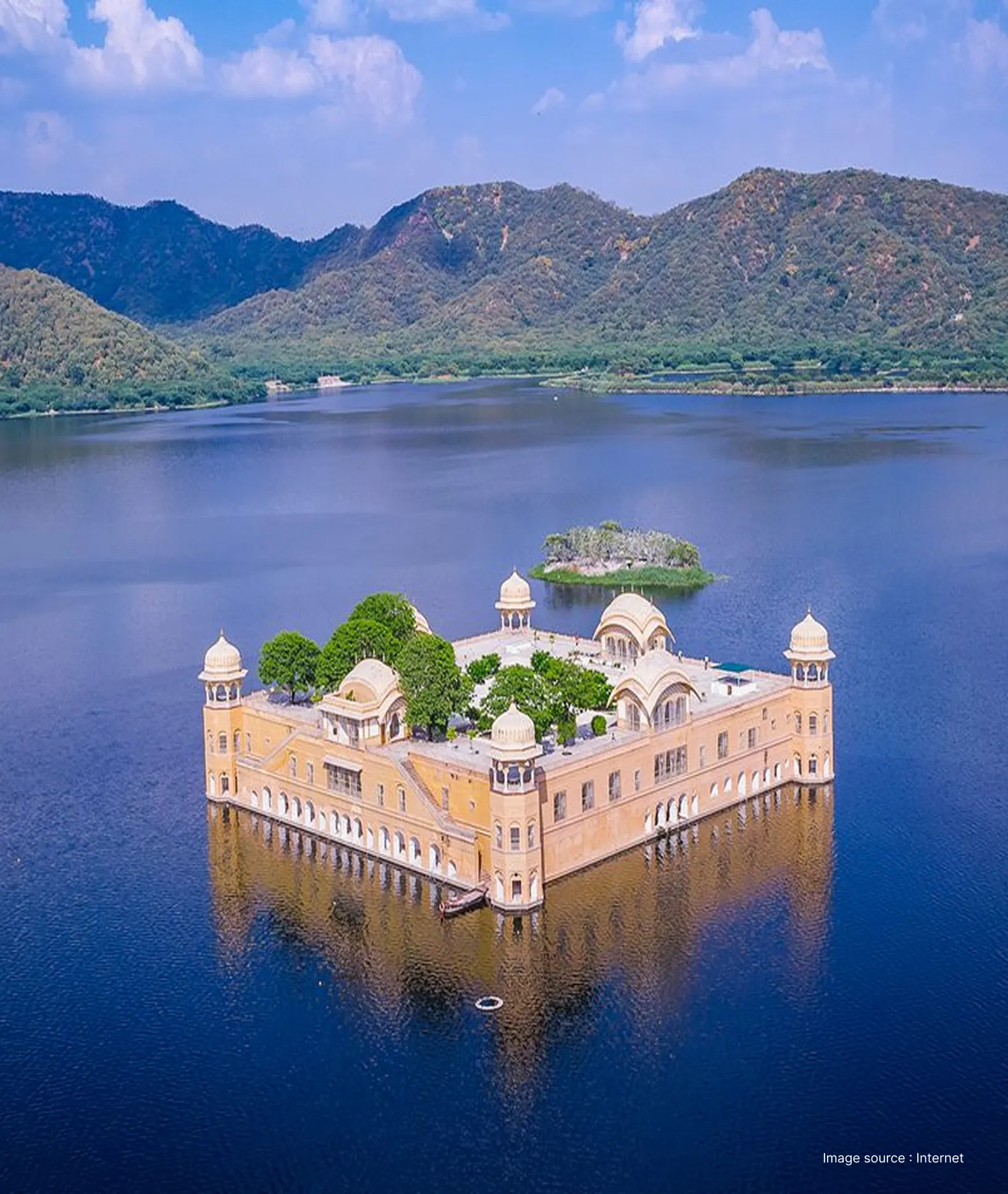 an aerial shot of the jal mahal in jaipur, floating in the middle of a lake