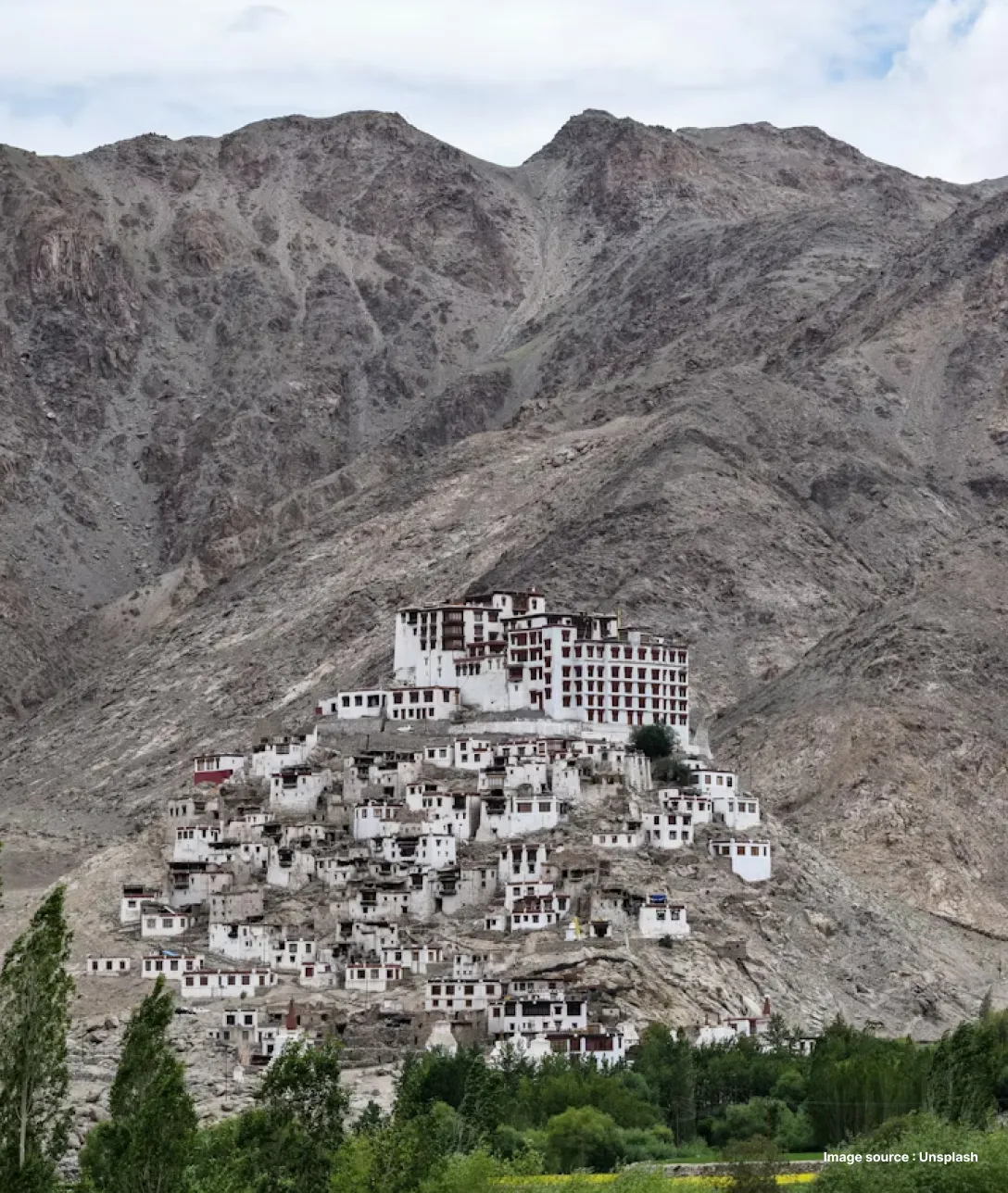 a distant shot of a valley with a group of white buildings