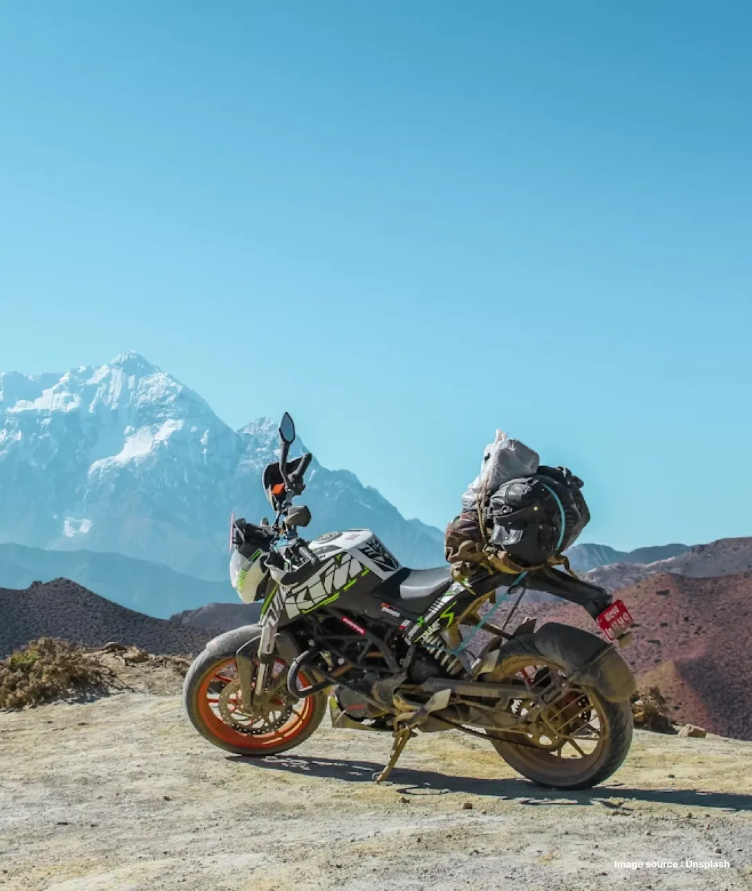 a motorbike parked by a cliff on a mountain pass