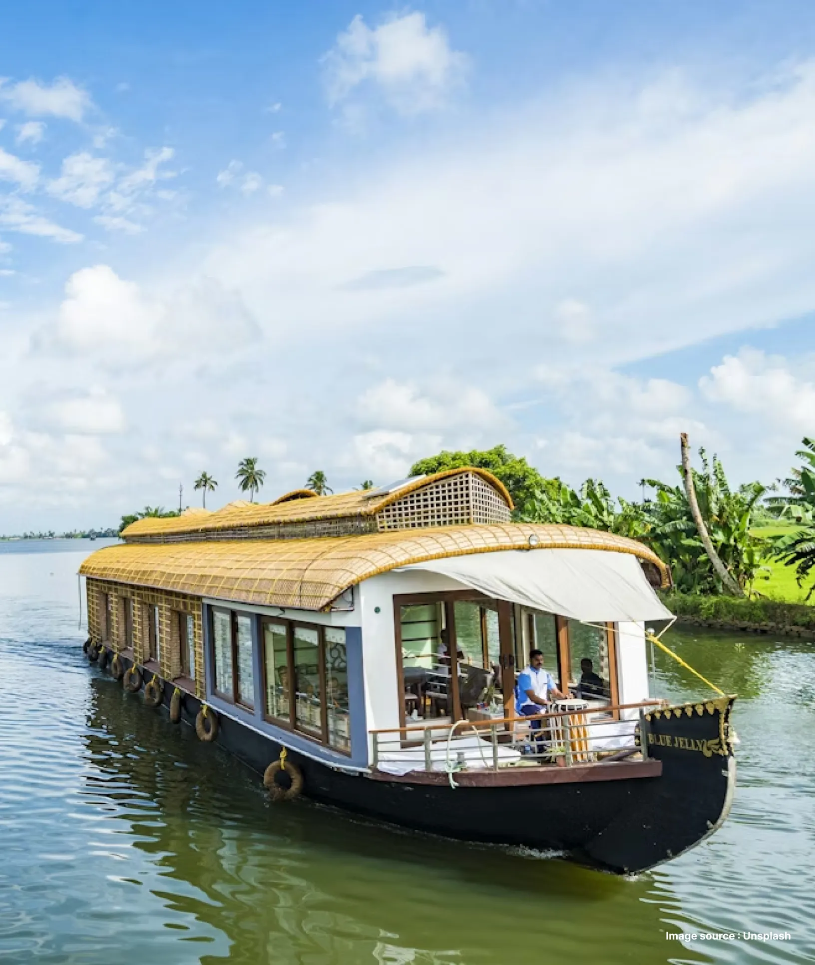 a traditional houseboat cruising backwaters in kerala on a clear day