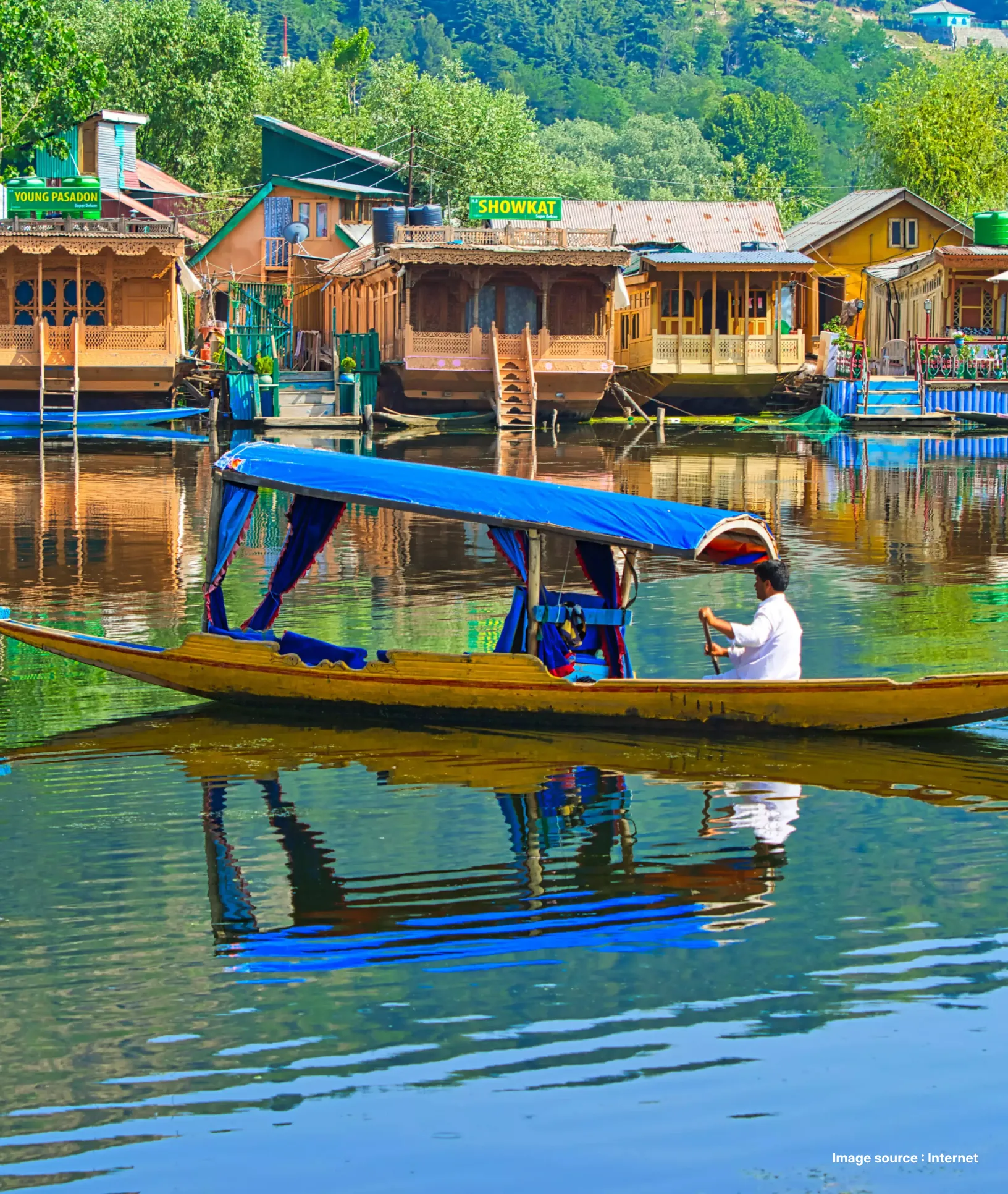 tourists enjoy a traditional shikara ride in dal lake with houseboats in the background