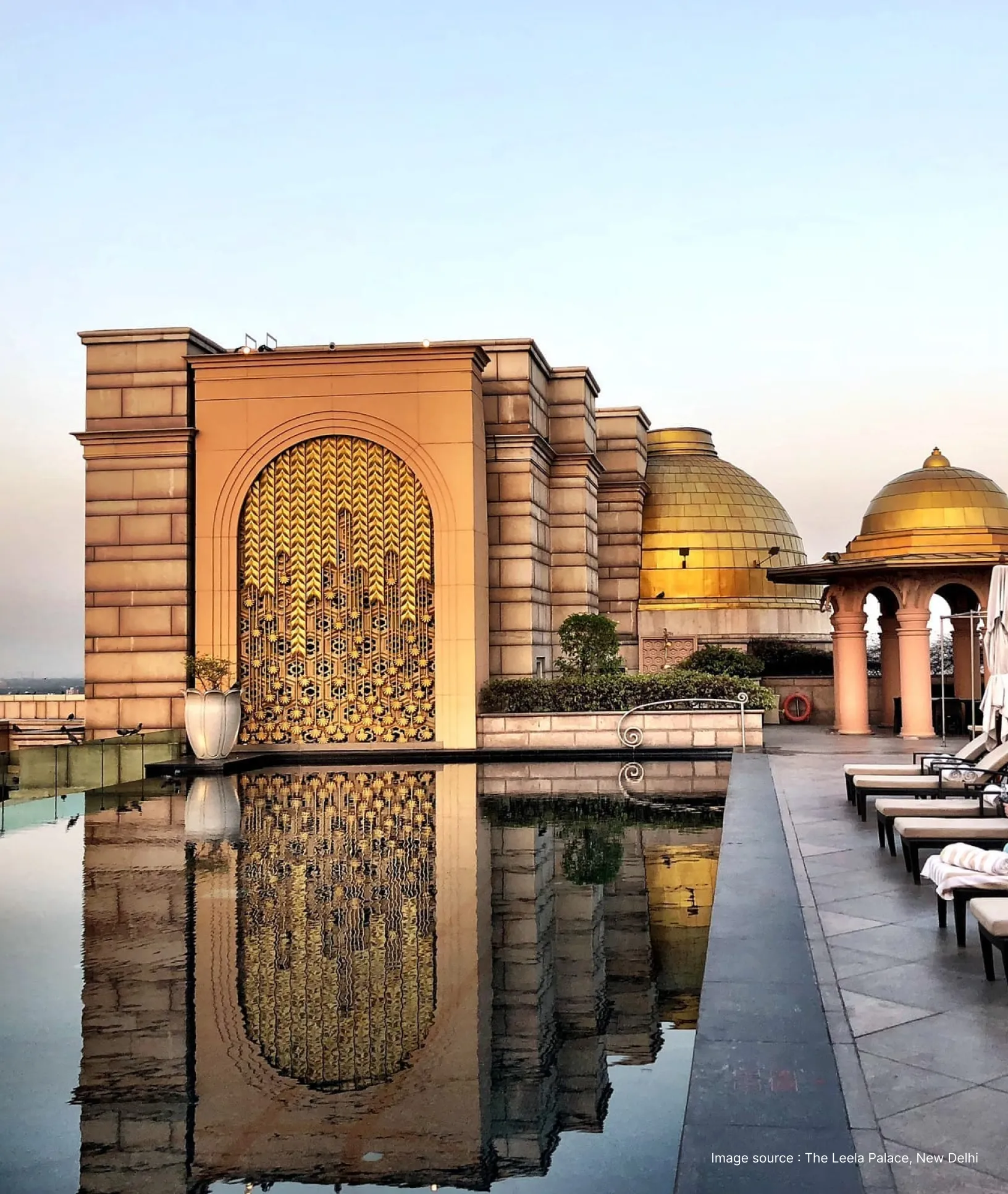 pool side view with opulent golden structures and a cenotaph at the leela palace delhi