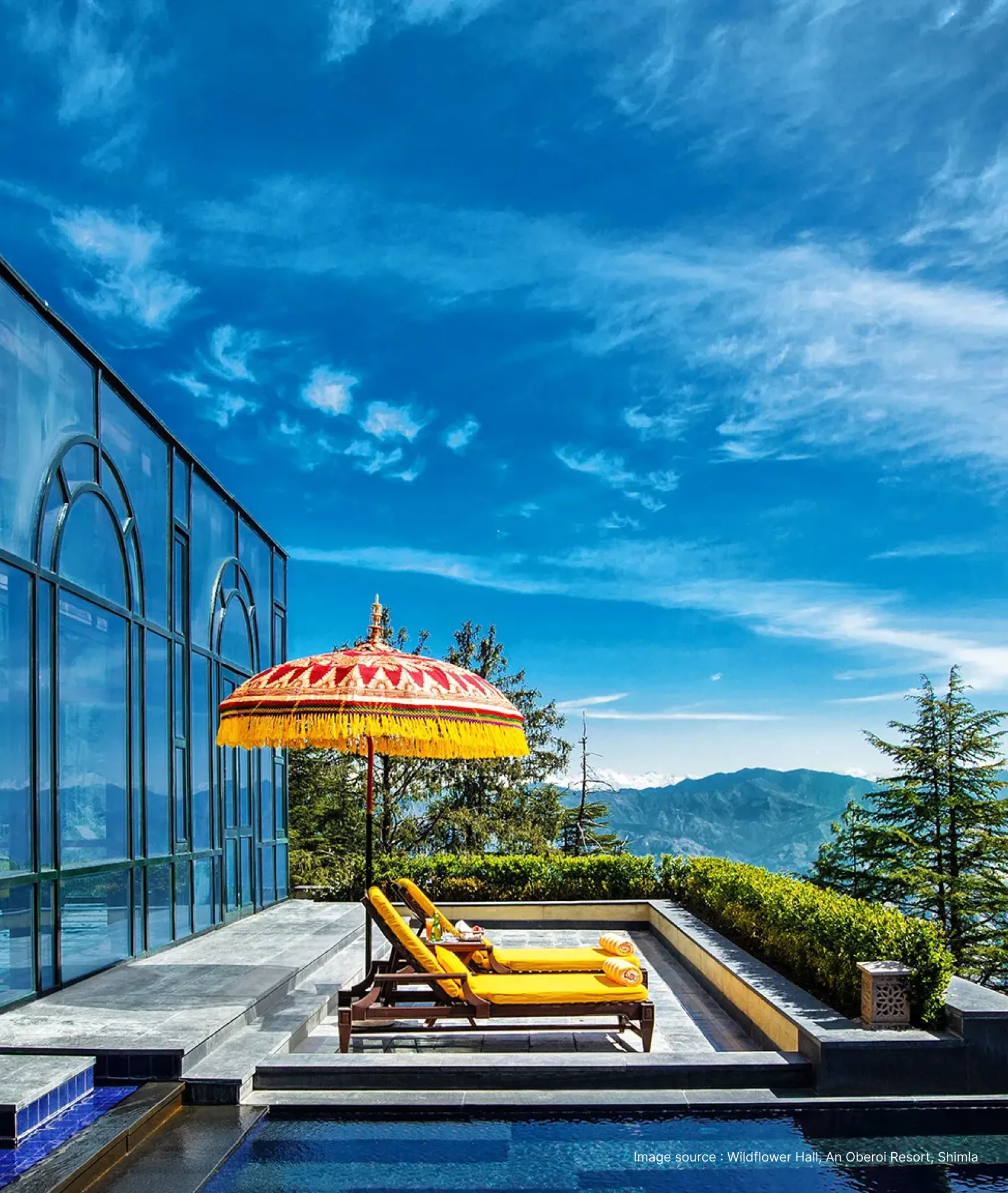 poolside lounge chair with decorated umbrellas at the oberoi wildflower resort with clear sky