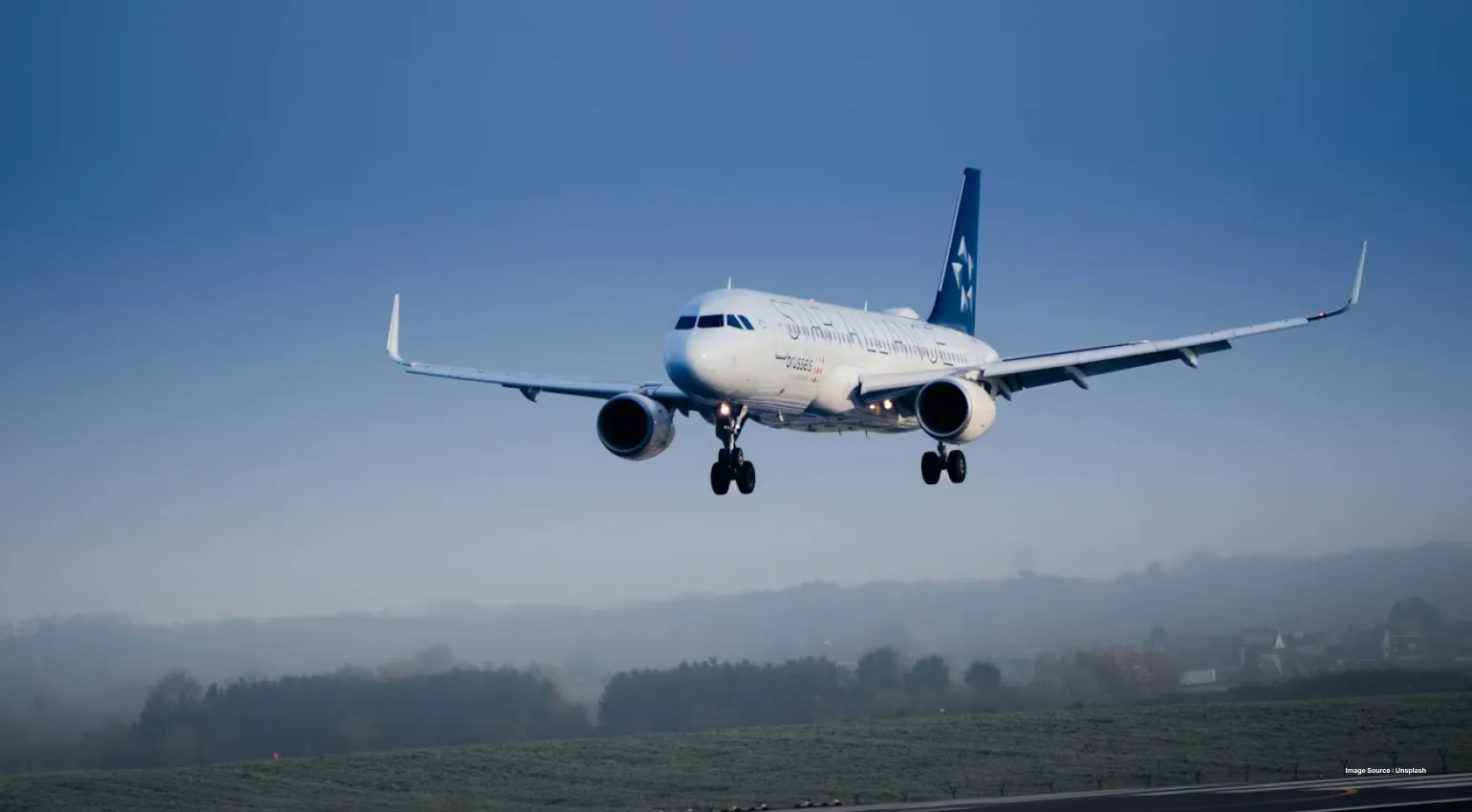 An aeroplane about to land with the blue sky