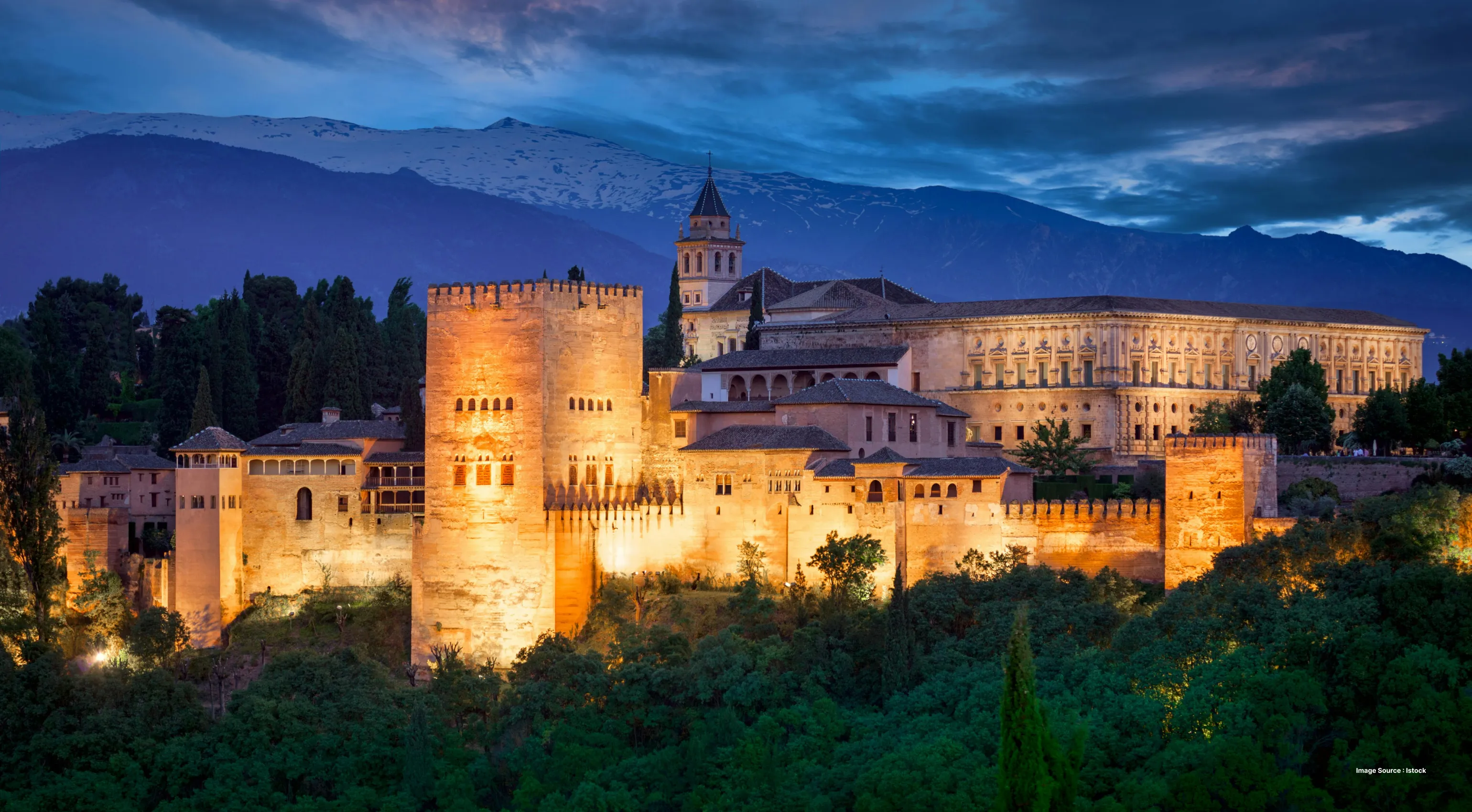 night view of the alhambra palace with lighting and dark clouds