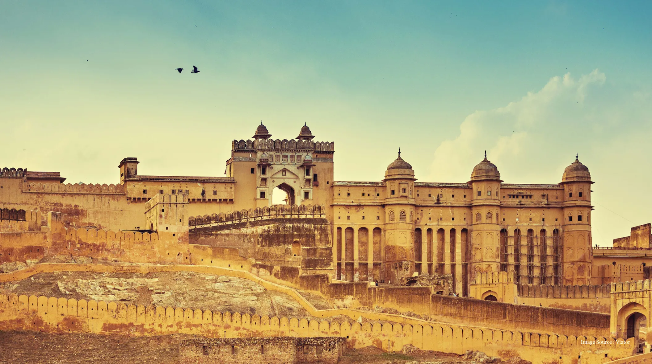 first-time-guide-luxury-india-travel: Historic Amer Fort with classic Rajasthan architecture under a clear sky.