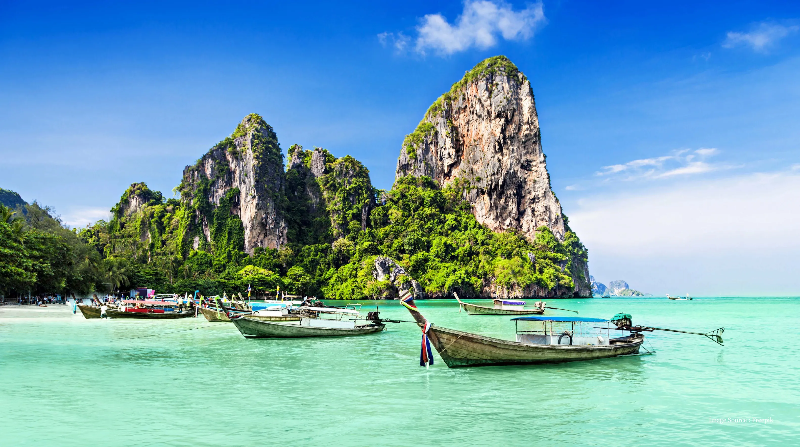islands-tours: Traditional boats on turquoise water with lush green Andaman islands cliffs.