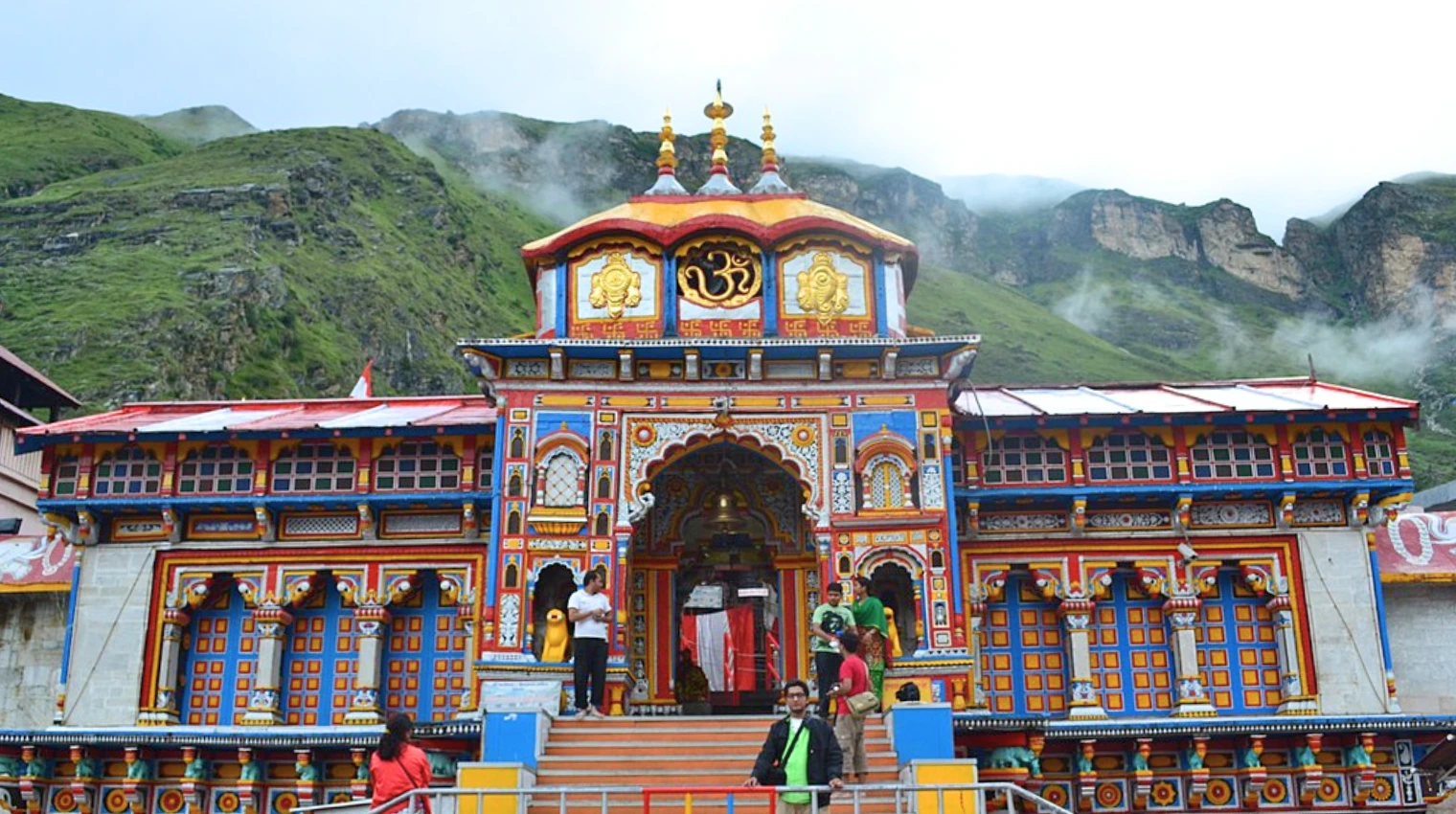 Front view of Badrinath Temple surrounded by mountains for an Indian temple tour experience