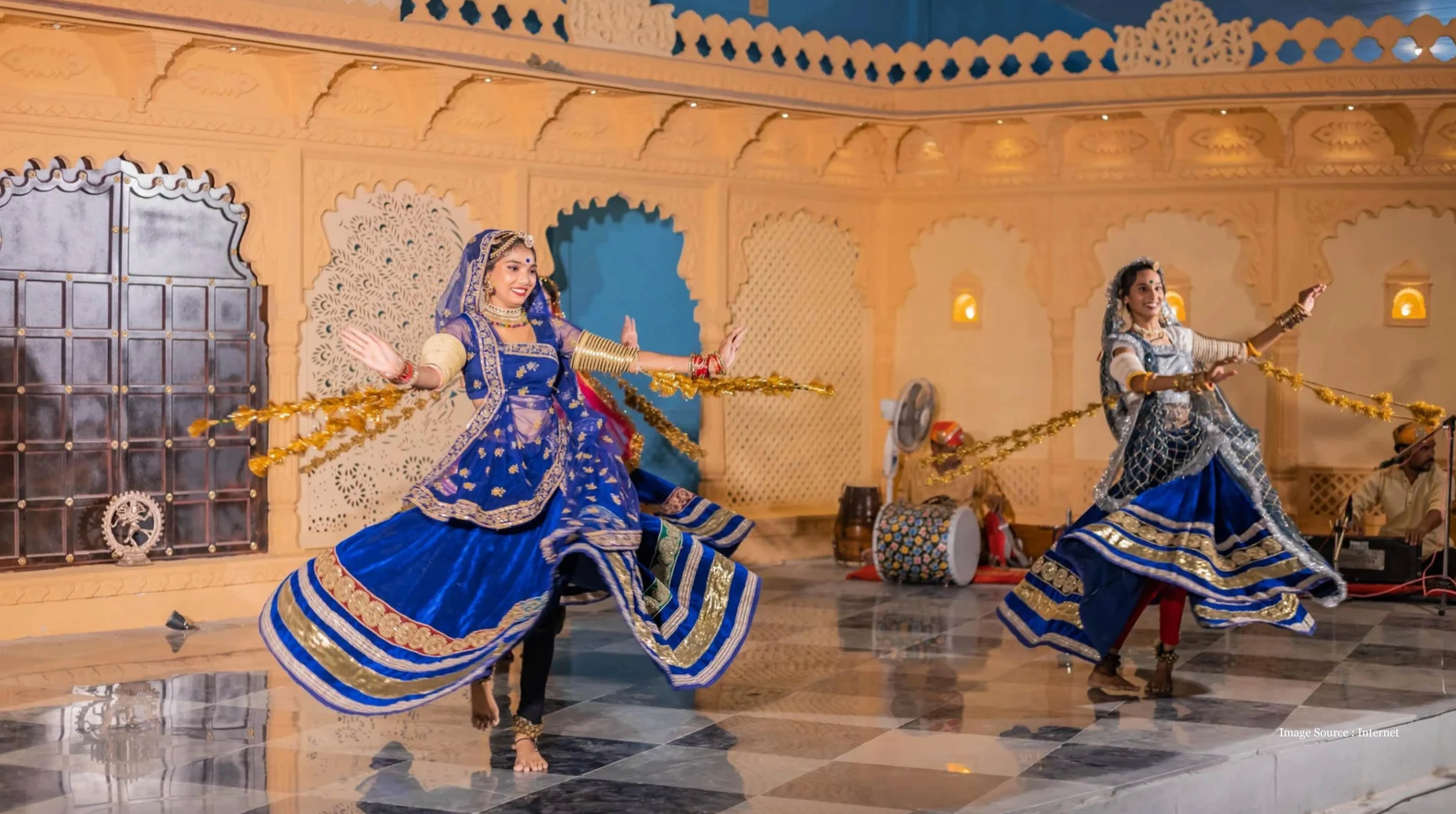 Luxury Udaipur tour featuring vibrant Rajasthani folk dancers performing in traditional attire at Bagore Ki Haveli, showcasing cultural elegance and royal ambiance