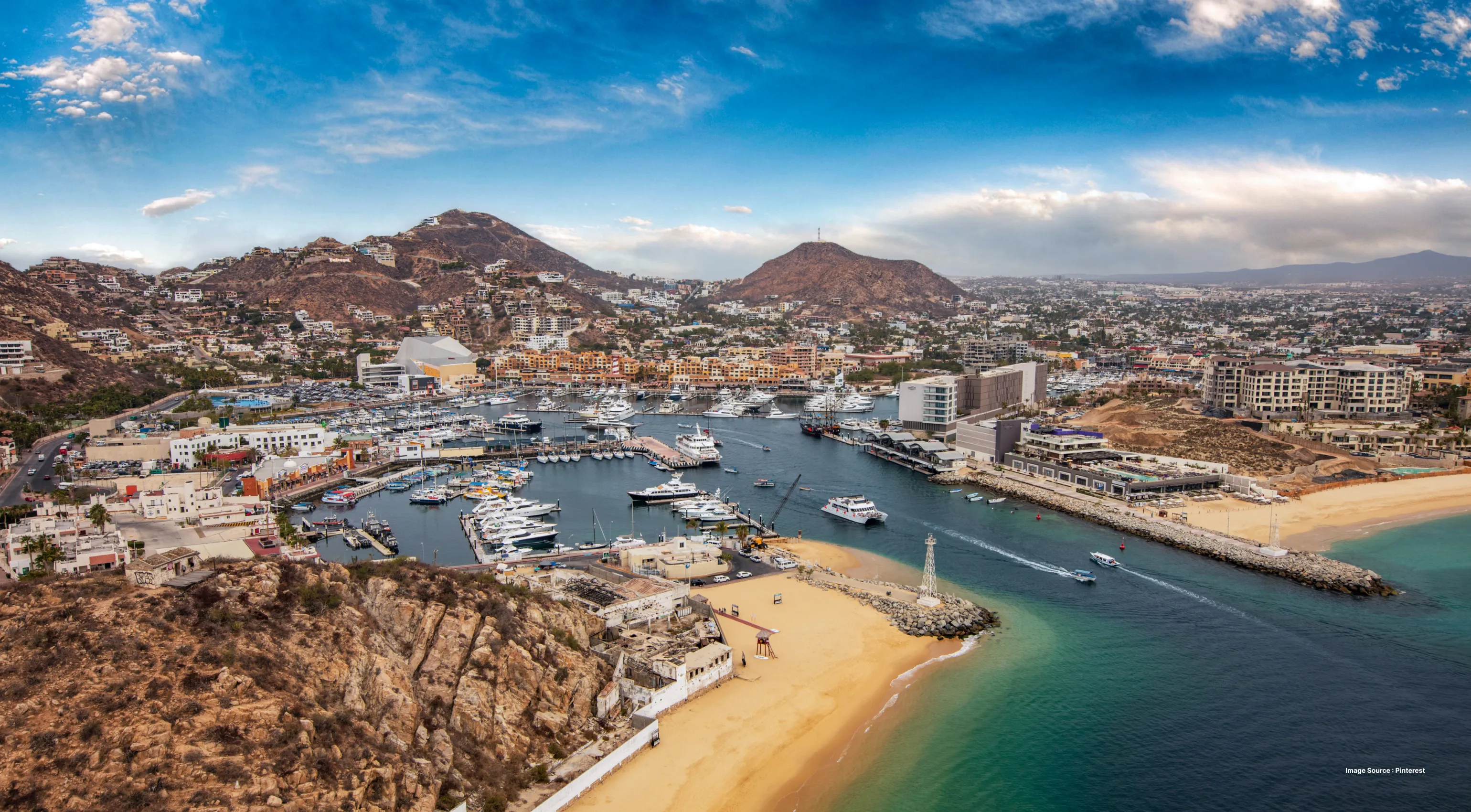 aerial shot of the cabo san lucas city's coastline with mountains in view
