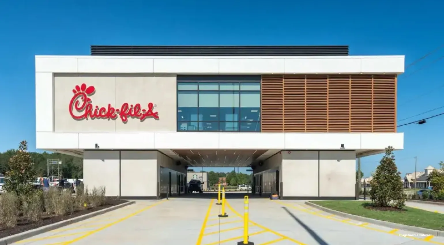 Modern Chick-fil-A restaurant exterior with a drive-thru lane passing beneath the building and the Chick-fil-A logo displayed on the front facade.