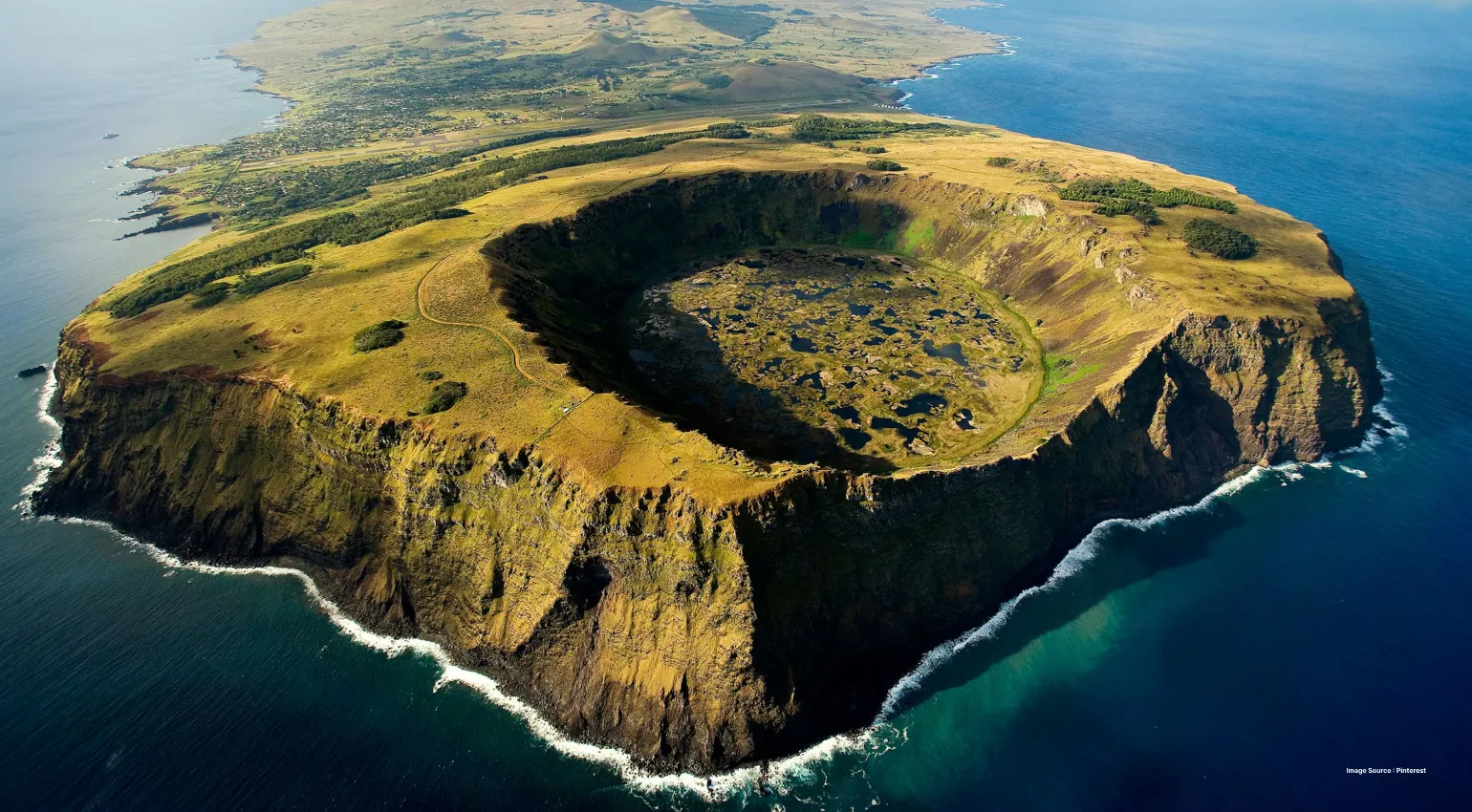 aerial shot of rapa nui island's green hill with a crater