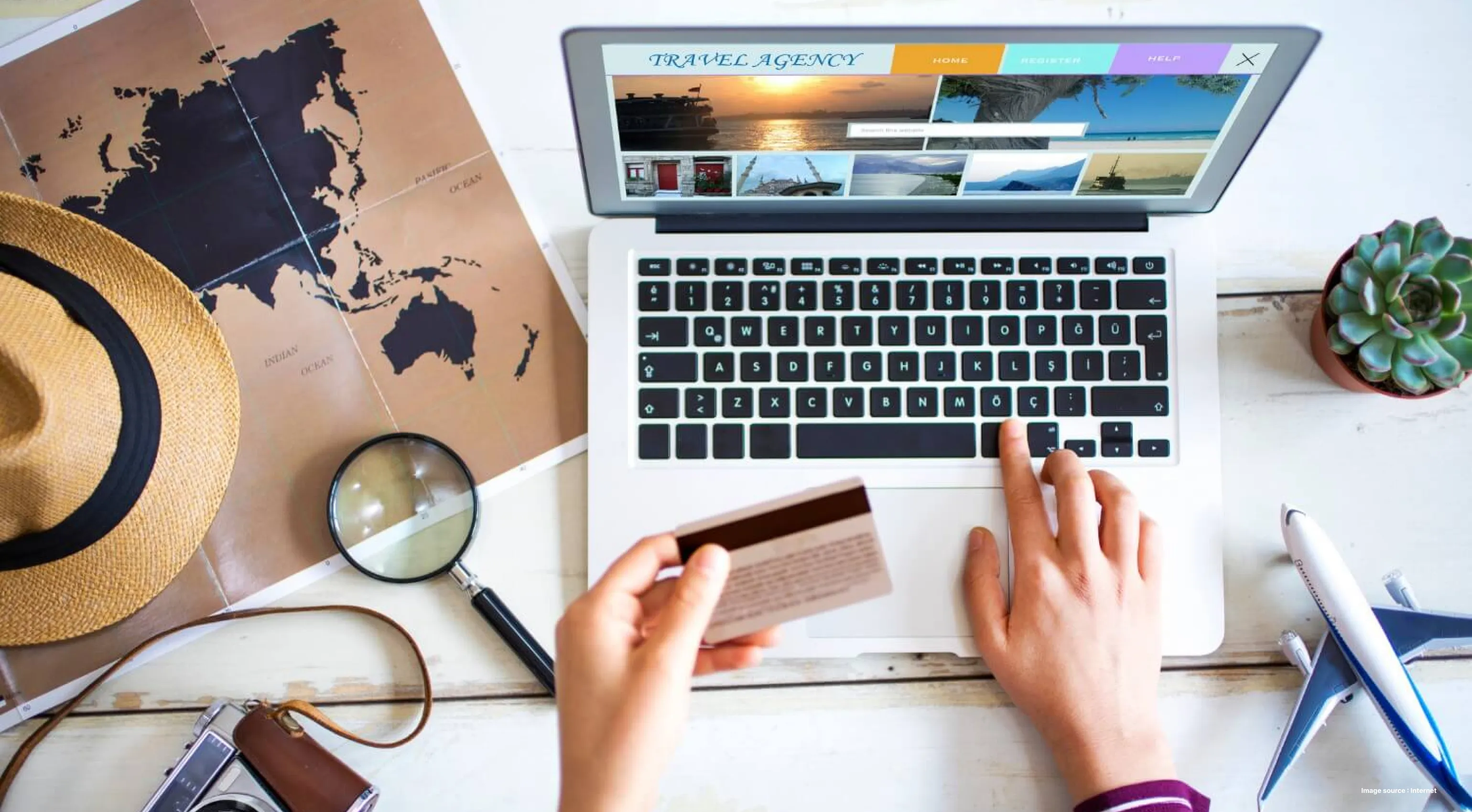a person holding up a debit card in hand while paying for a travel experience online