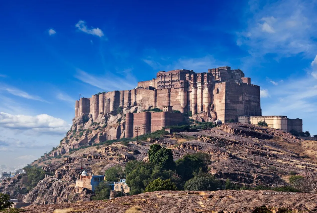 Indian Culture tour: Mehrangarh Fort in Jodhpur, historic fort on rocky hill under blue sky