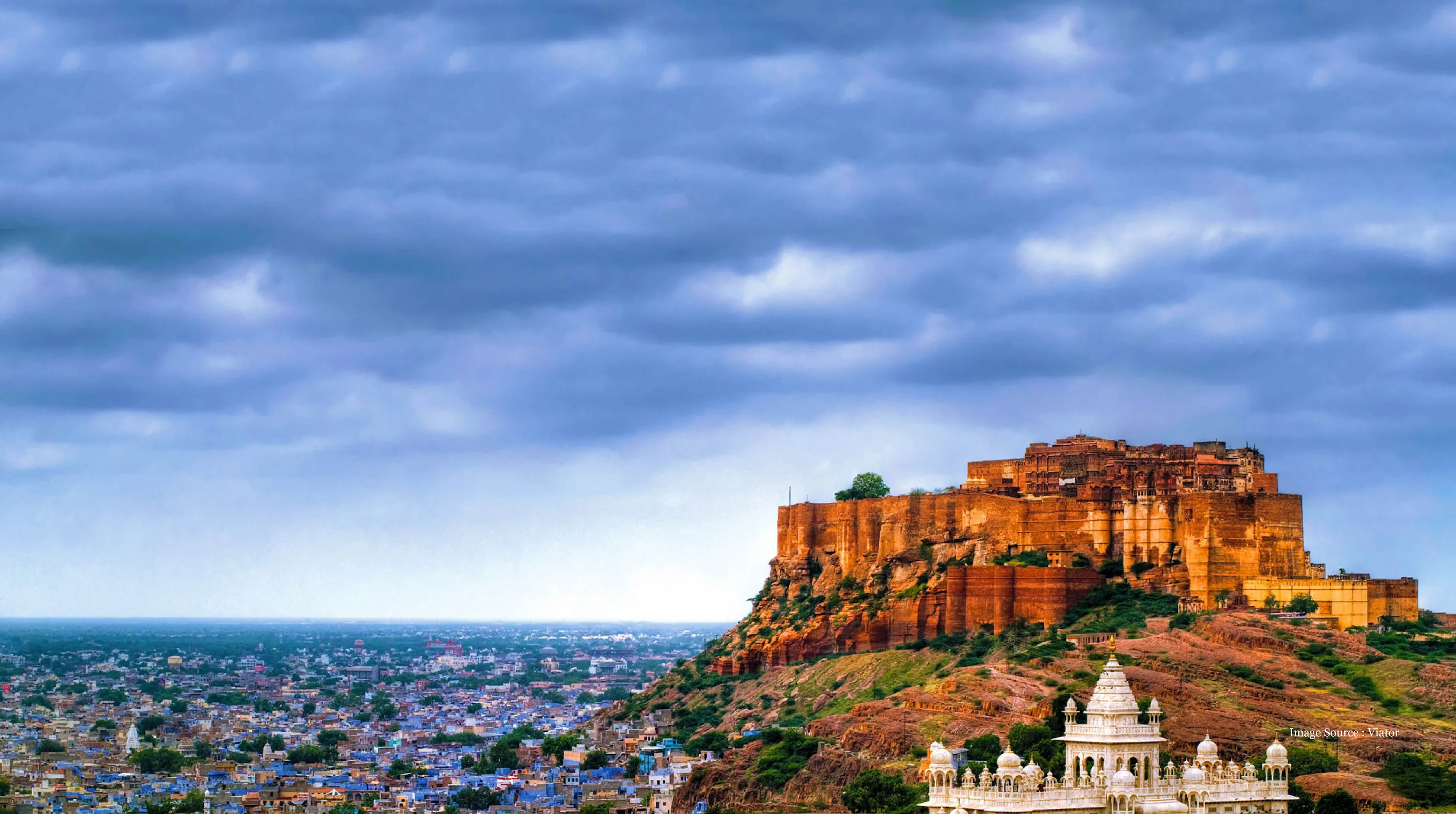North India-vs-South India luxury tour featuring the majestic Mehrangarh Fort rising above Jodhpur's vibrant cityscape under dramatic skies