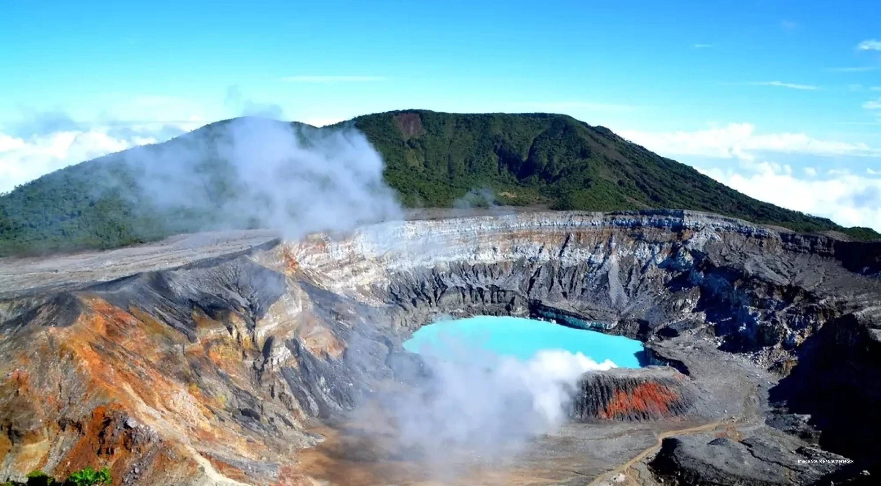 mist rising from a spring in a crater shaped pong with green hill in the background