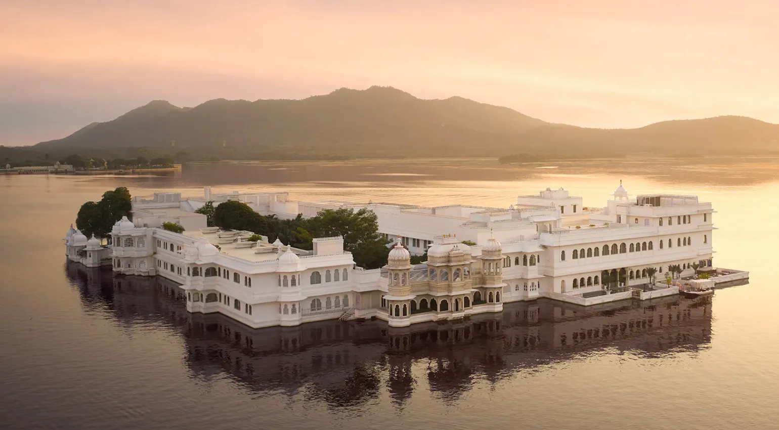 an aerial view of taj lake palace in midst of the lake pichola