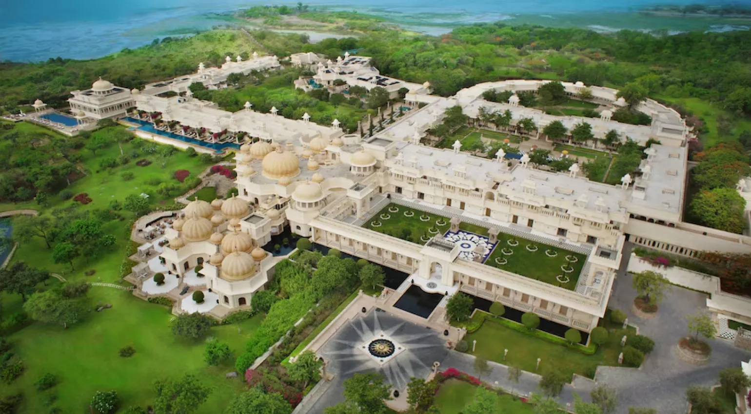 Aerial view of sprawling palace resort amid lush landscapes