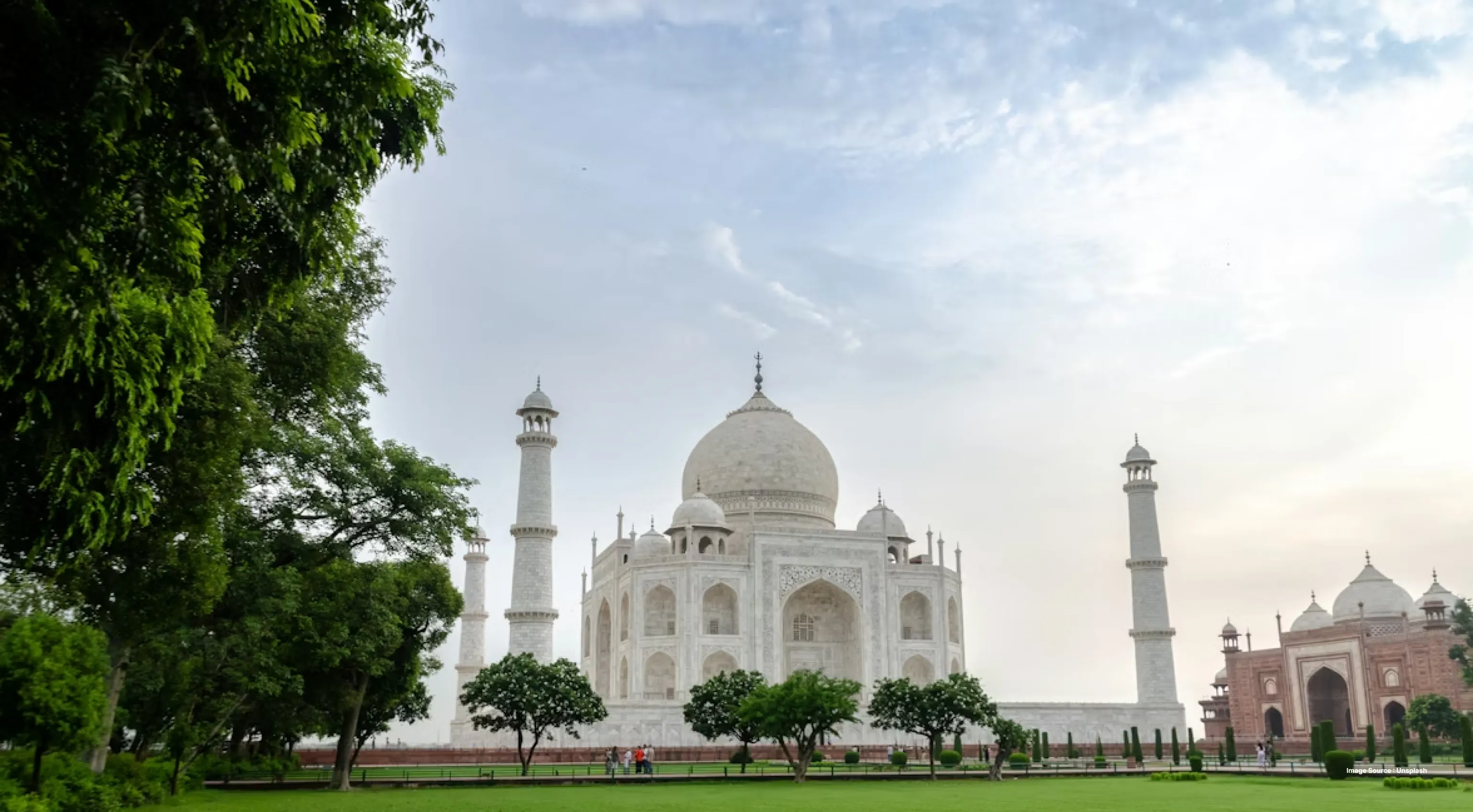 side view of taj mahal on a clear sunny day with trees in view