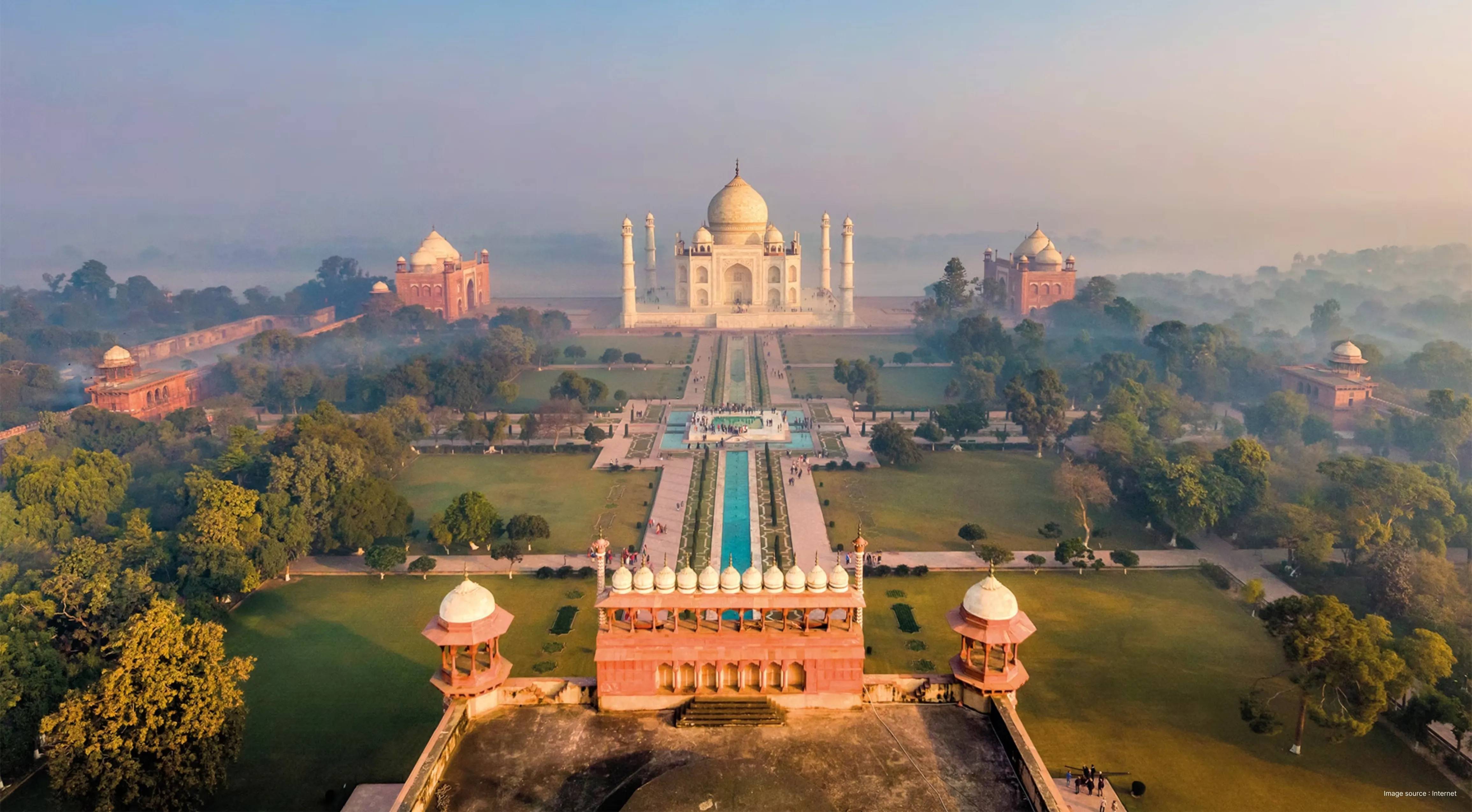 "Aerial view of the white marble Taj Mahal and the Great Gate (Darwaza-i-rauza) in Agra, India, answering the common travel question: where is the Taj Mahal?"