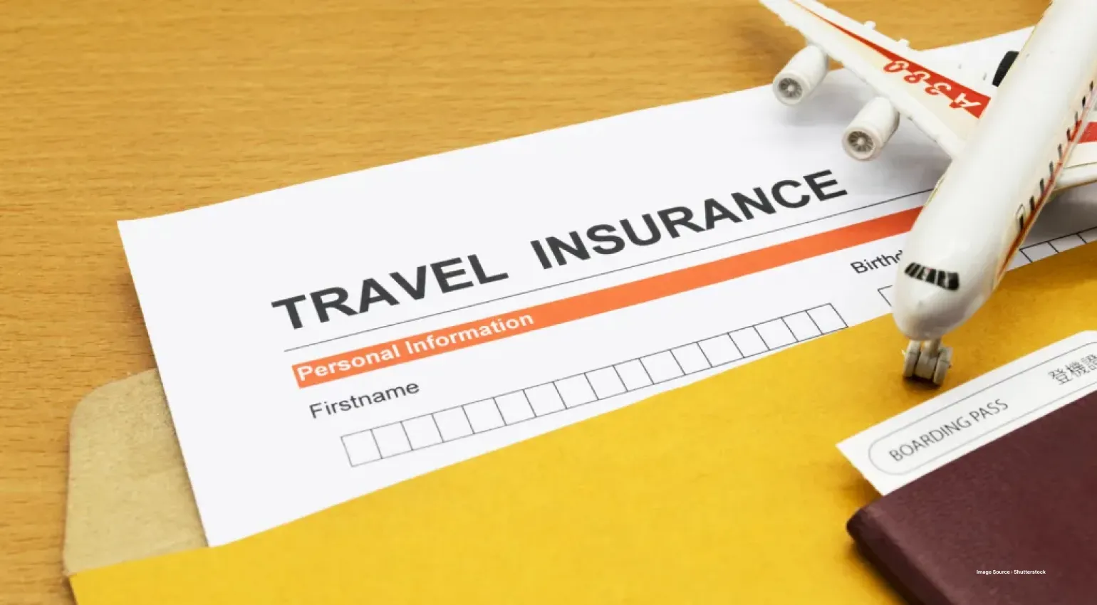a yellow folder with travel insurance form and an airplane model on top