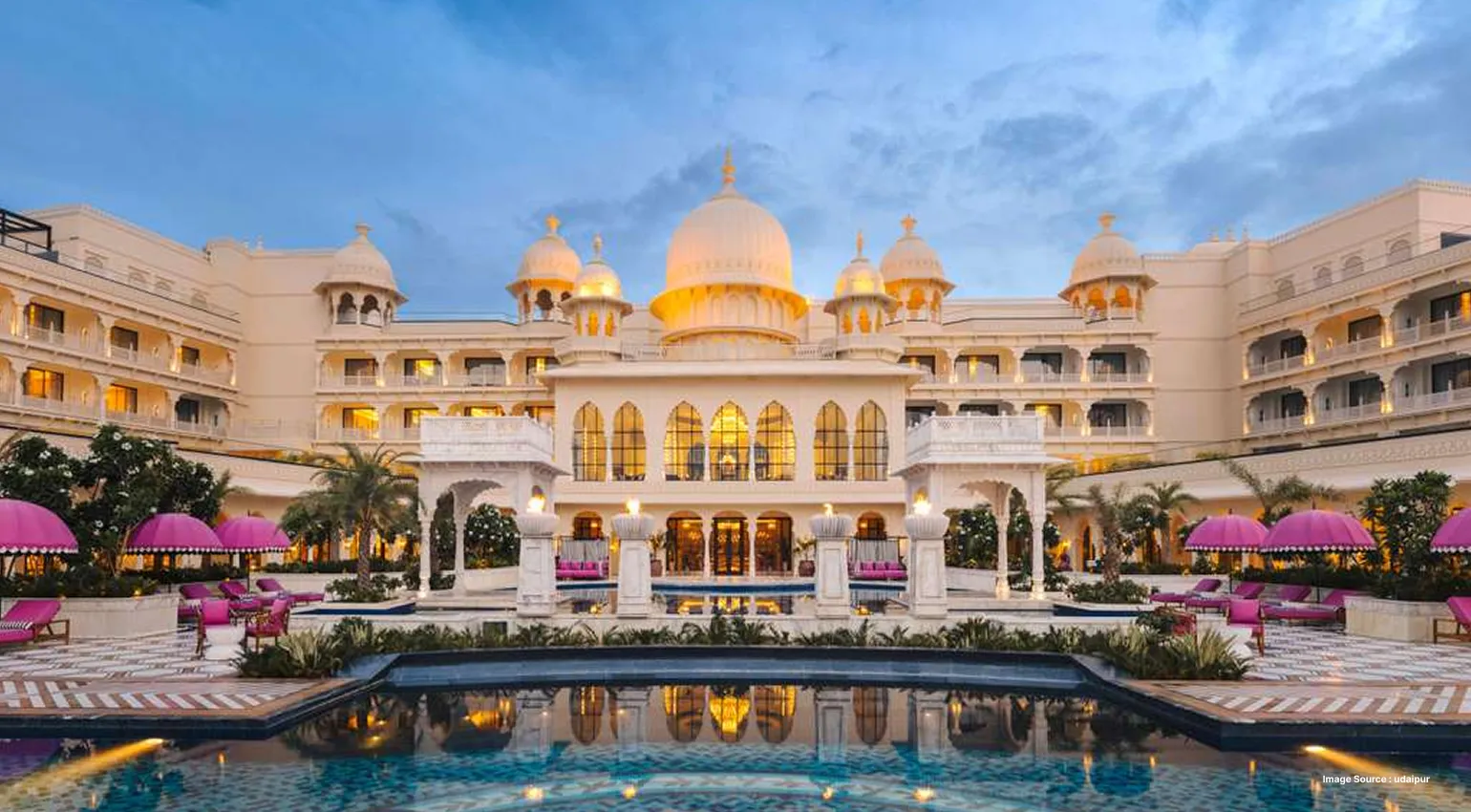 Elegant palace hotel with illuminated domes and poolside views