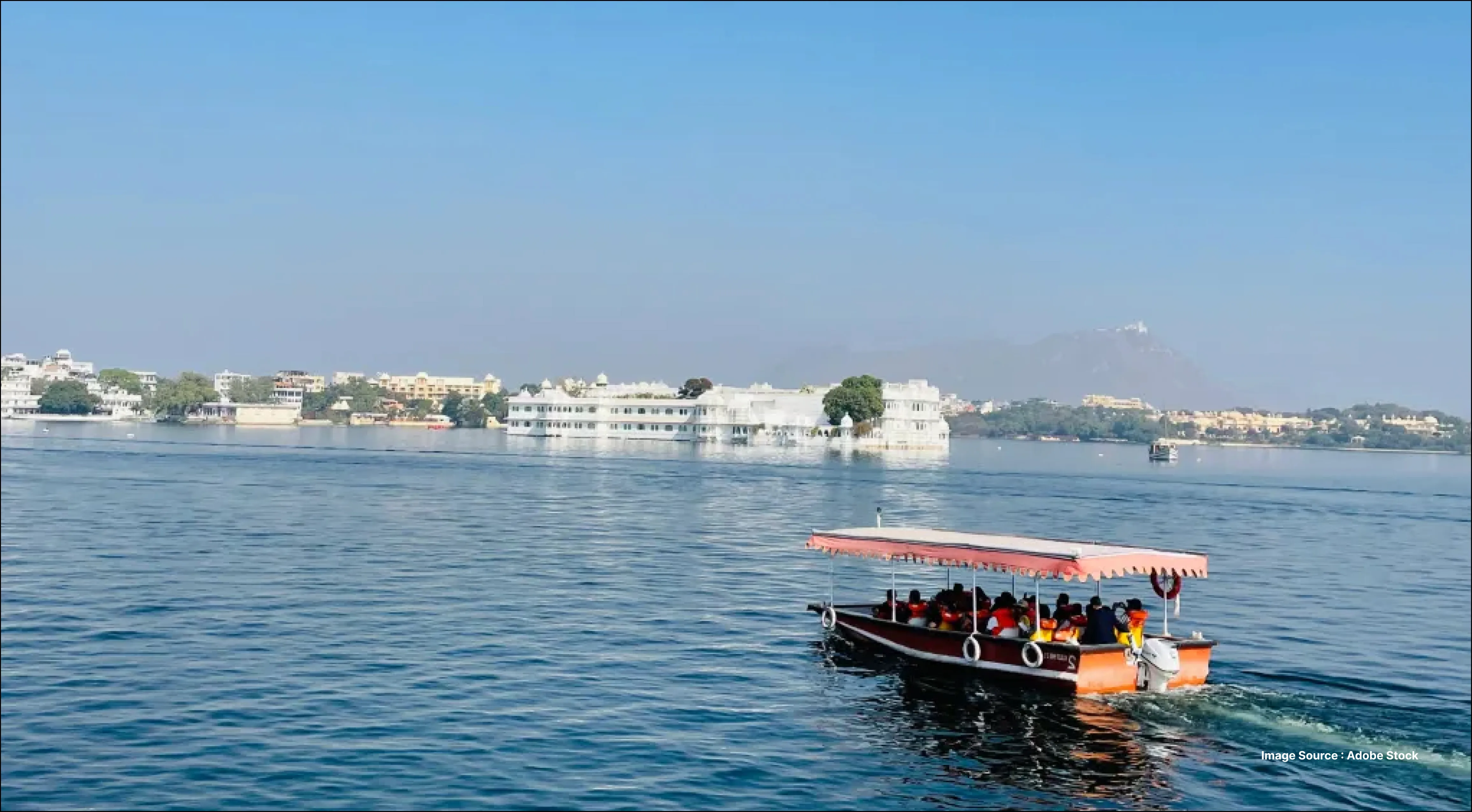 Scenic lake boat ride with travelers heading toward a palace island, offering Venice-holiday–style views on calm blue waters.