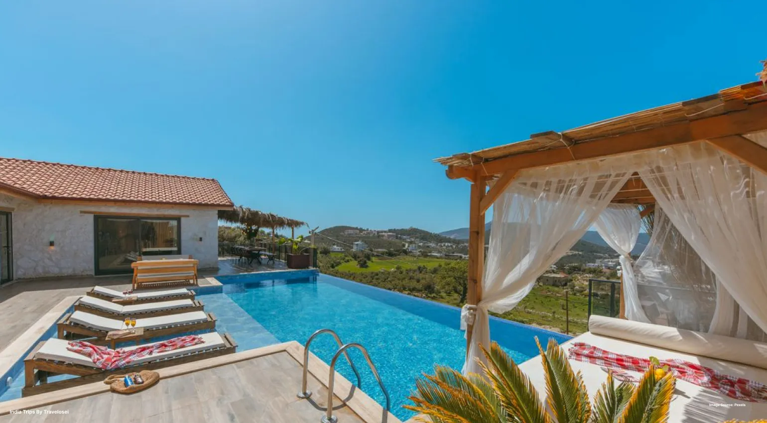 Infinity pool with a cabana overlooking scenic countryside views.