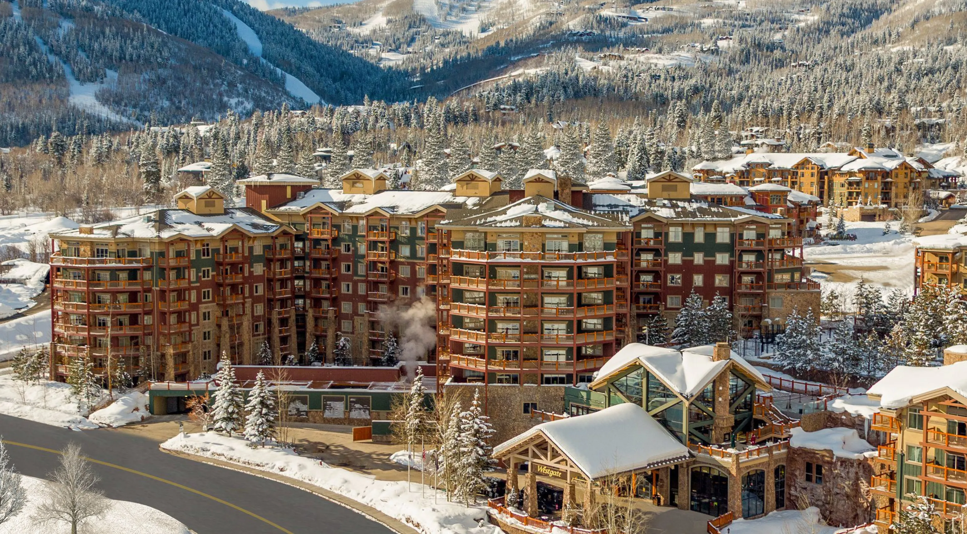 the westgate park city, a luxury ski resort in utah covered in snow with snow capped peaks in distance