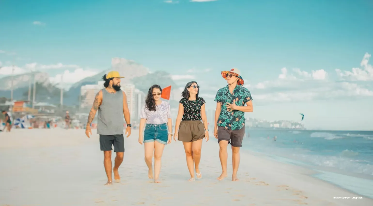 a group of 4 people walking on the beach