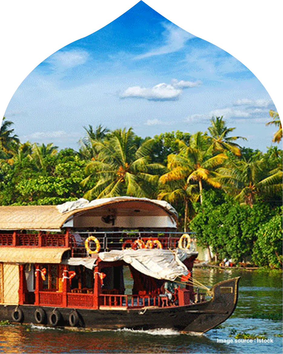 a scenic view of a houseboat sailing through the tranquil backwaters of Kerala