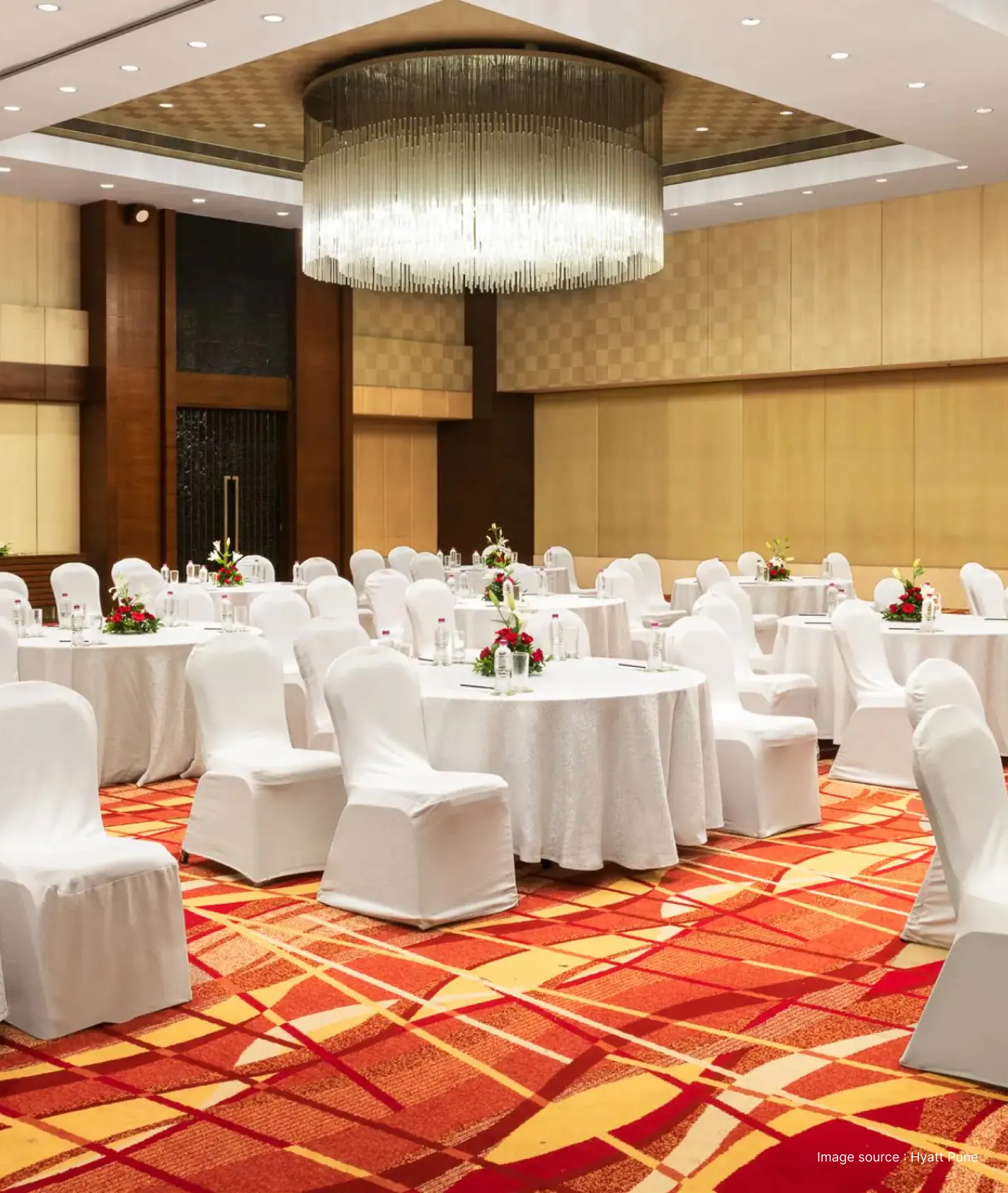 a meeting hall in hyatt pune with red carpet and white chairs