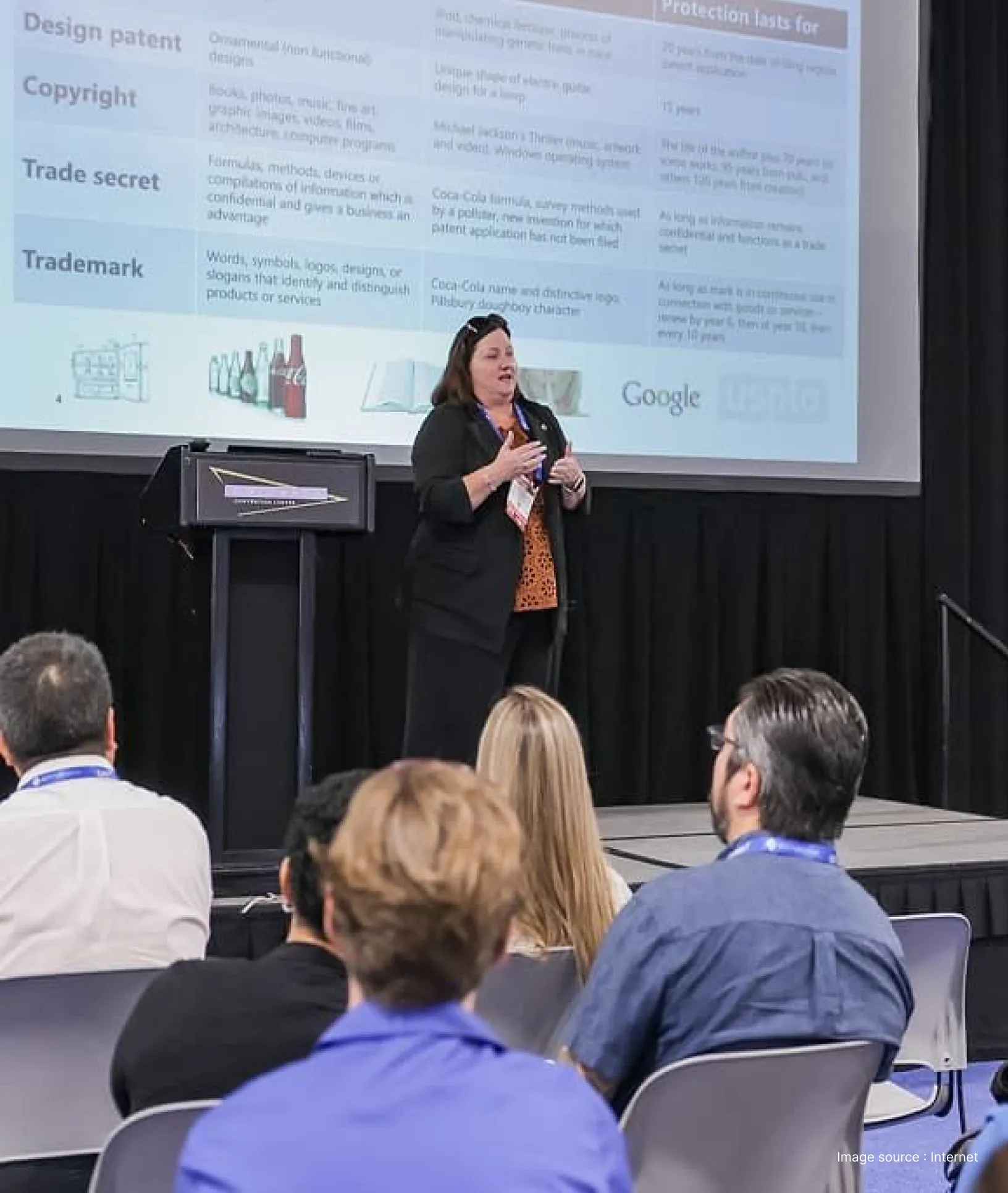 a woman speaker addresses the audience in a corporate meeting