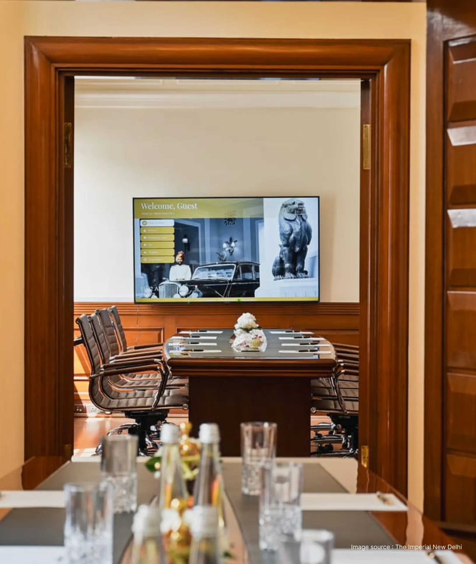 a meeting setup at a luxury hotel in india with a television and chairs