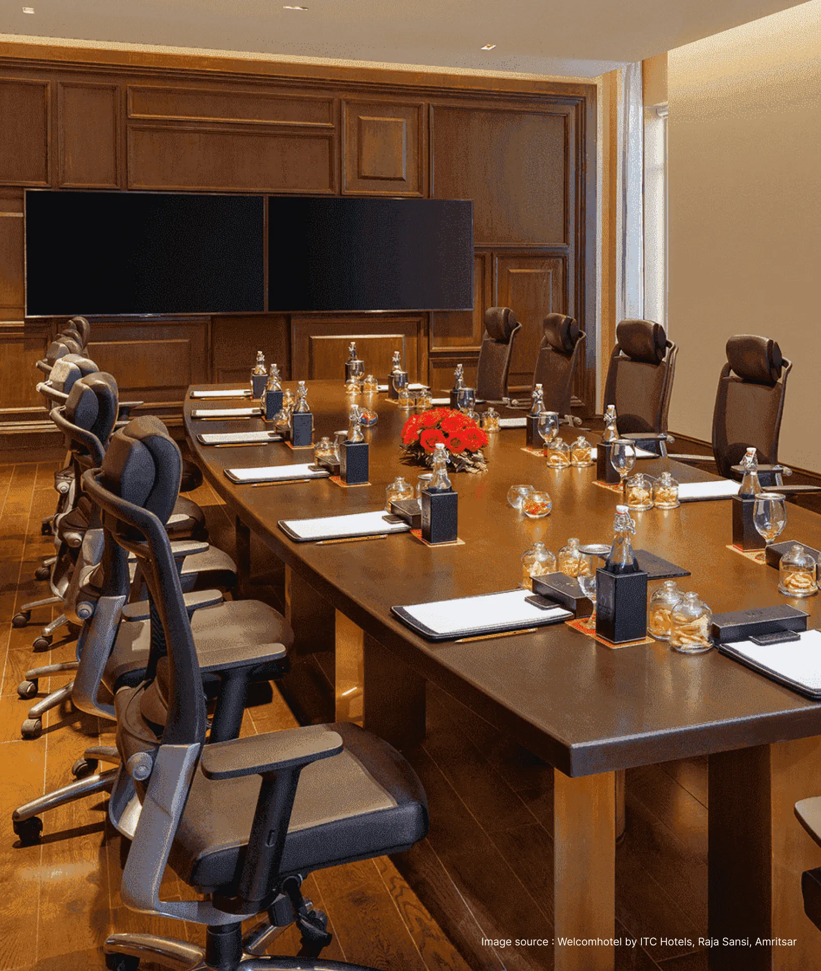 a meeting setup with wooden furniture and televisions