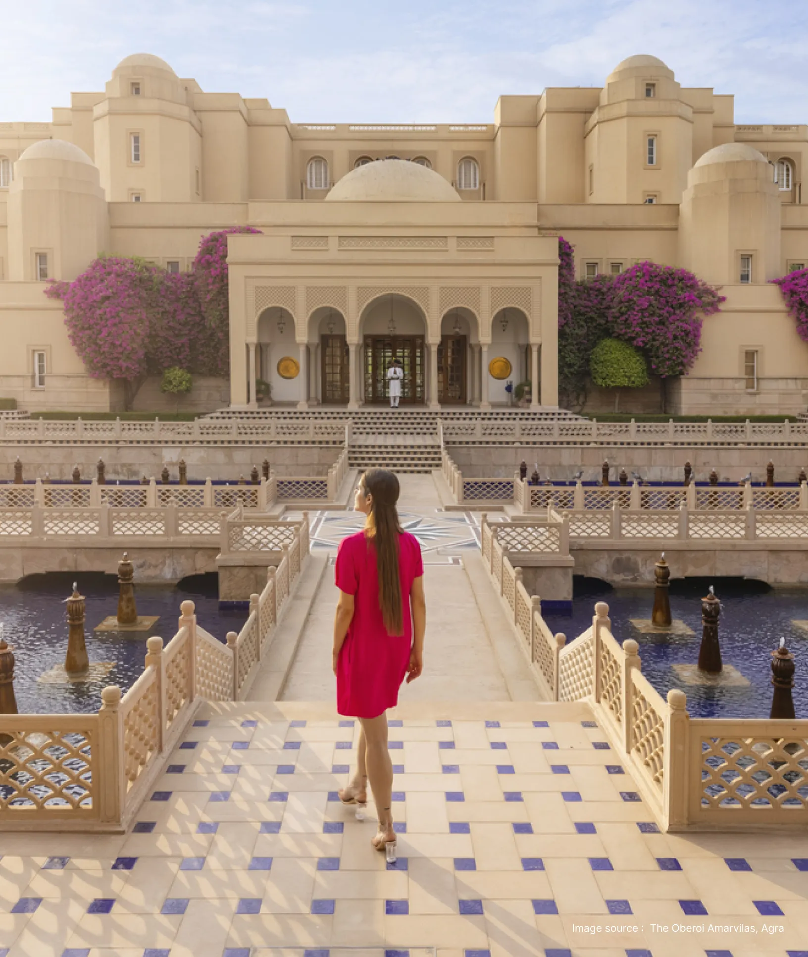 a woman in a red dress strolls at the oberoi amarvilas
