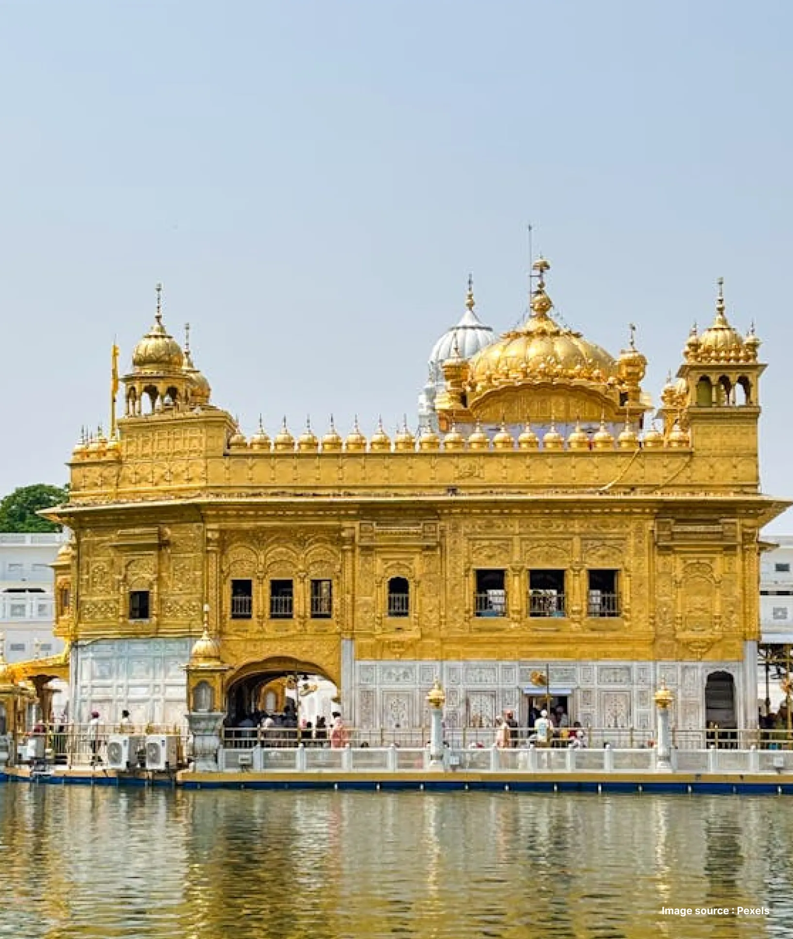 a side view of the golden temple with its pond in amritsar