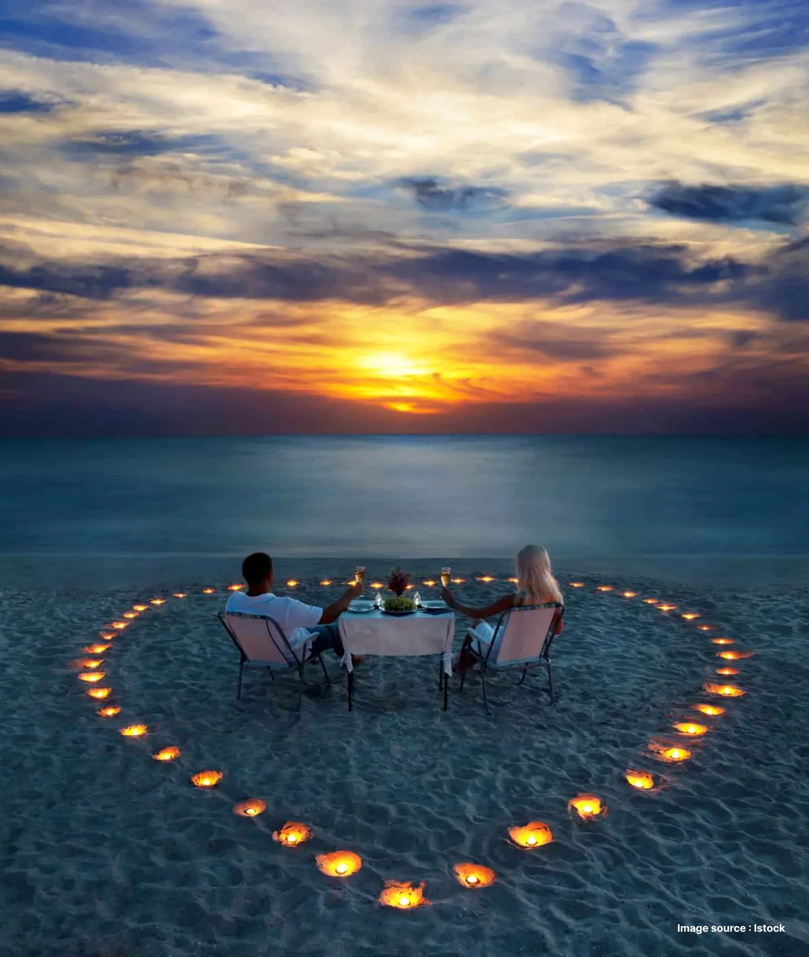candles put in a heart shape for a romantic beach dinner